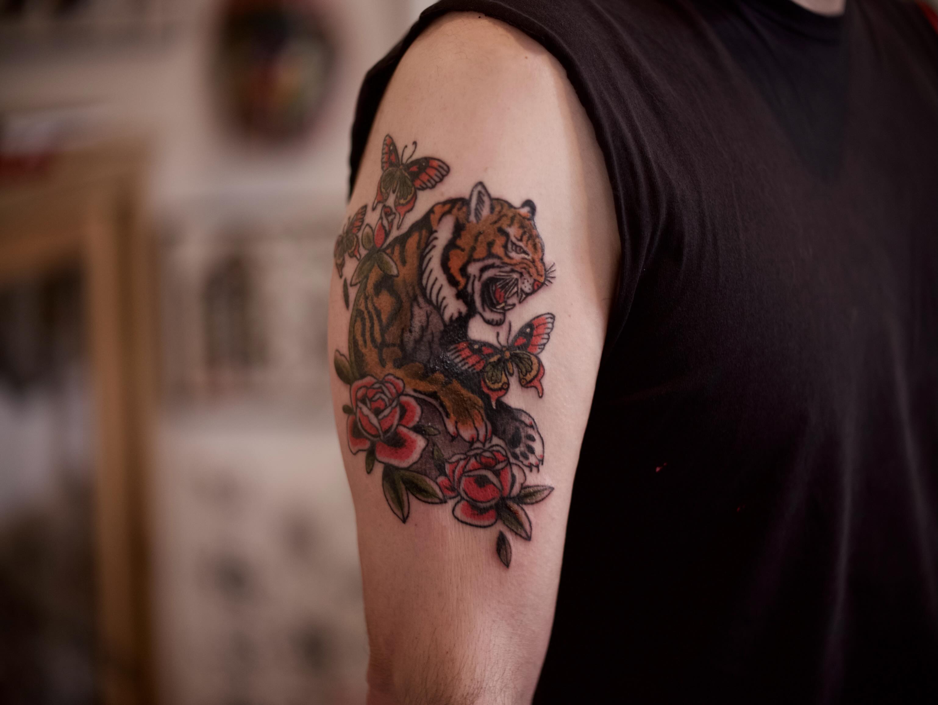 Tiger and roses American traditional tattoo on the forearm by Dylan Coverdale