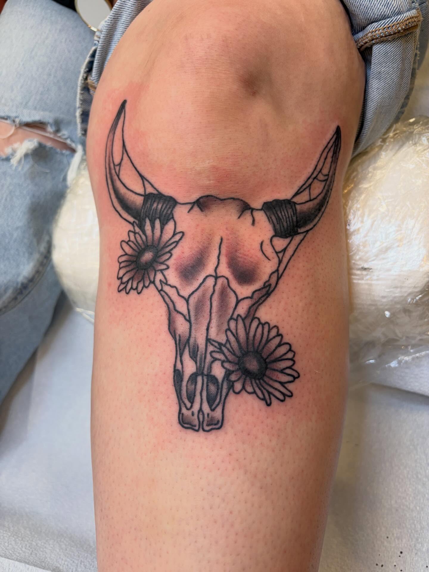 Bull skull with flowers black and grey tattoo on the forearm by Scrap Iron Tattoos