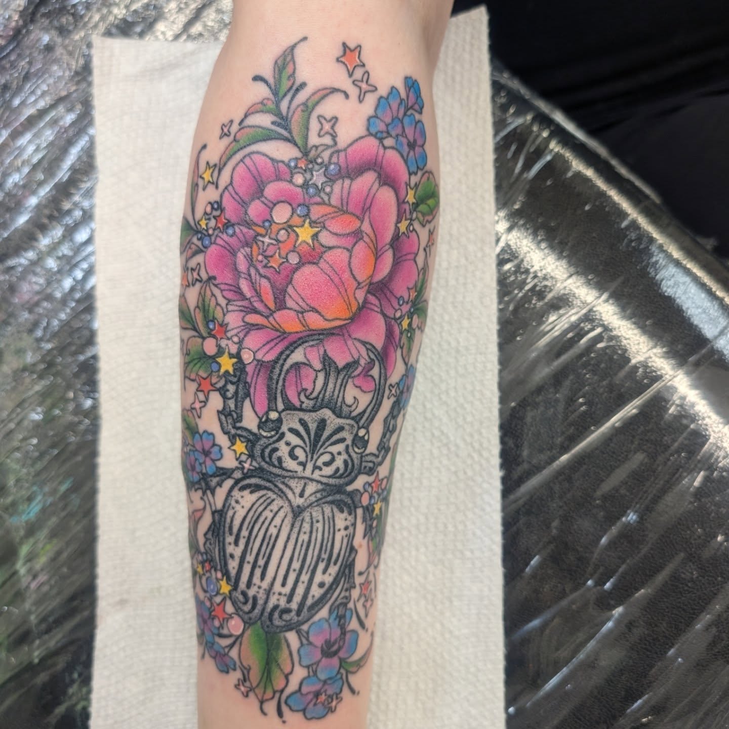 Beetle and floral bouquet new school tattoo on the forearm by Talia Zula, Loveland, Ohio