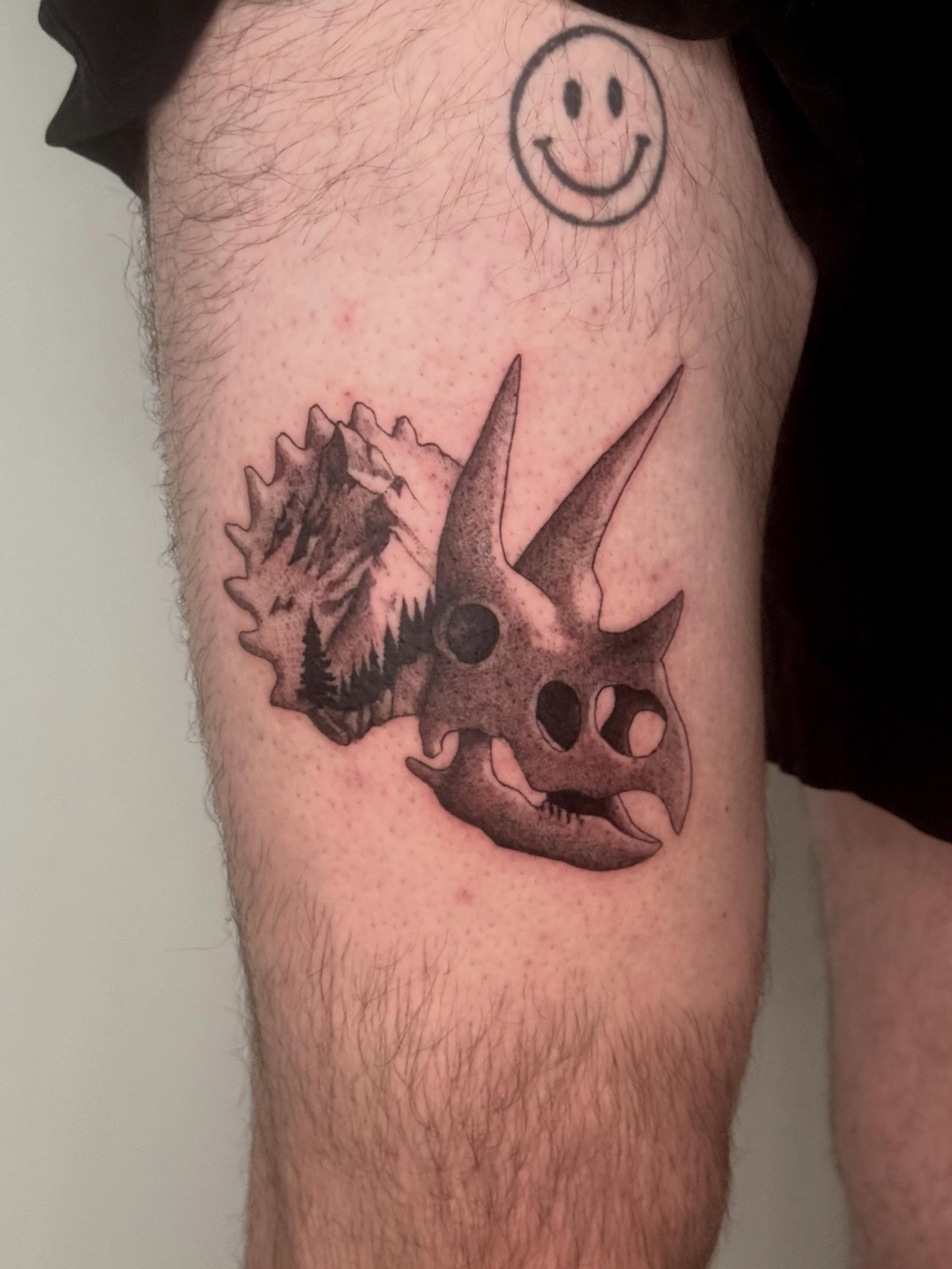 Triceratops skull black and grey tattoo on the thigh by Andrew Flatts