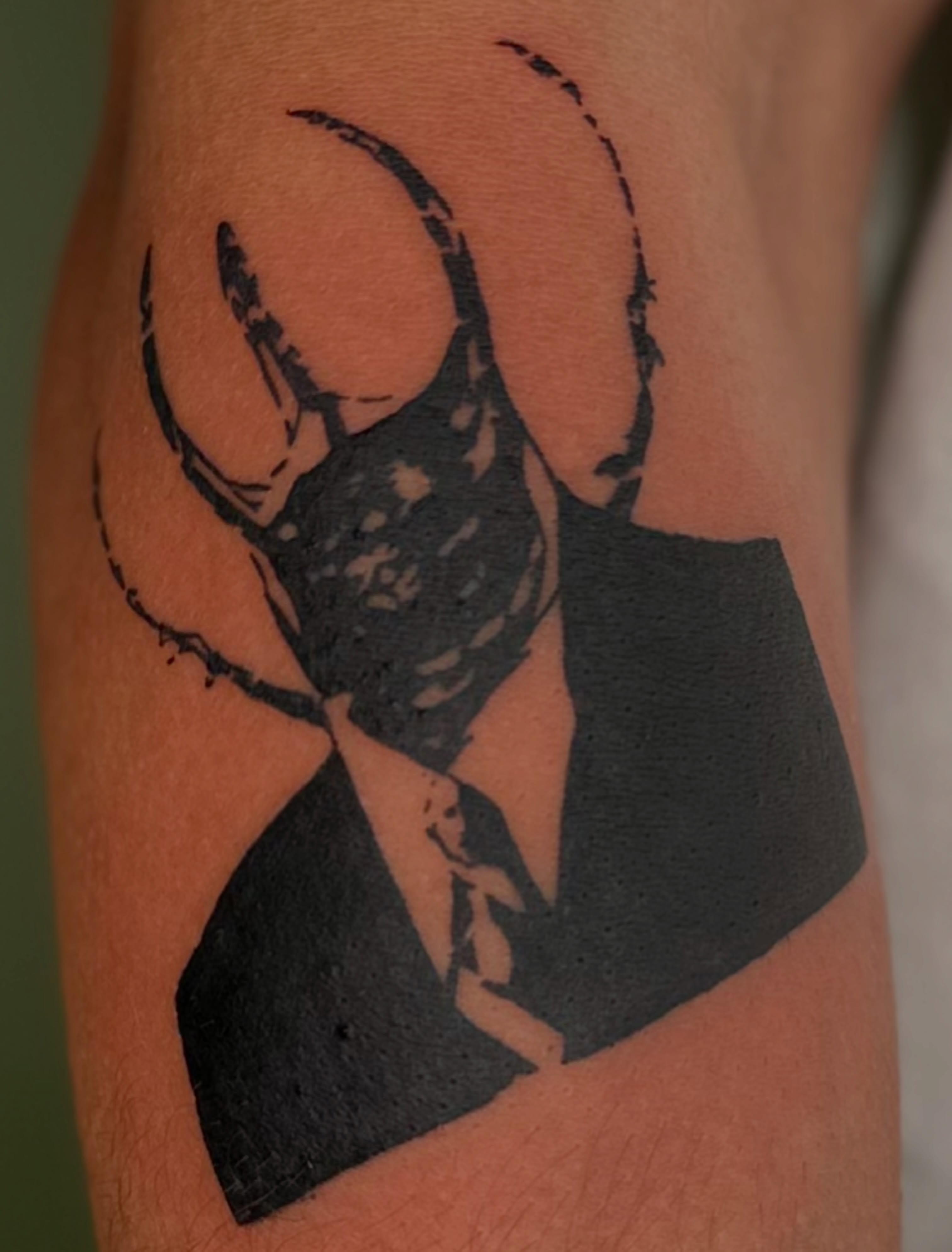 Stag beetle black and grey tattoo on the forearm by Nikolas Tapio Aatos Mäkelä