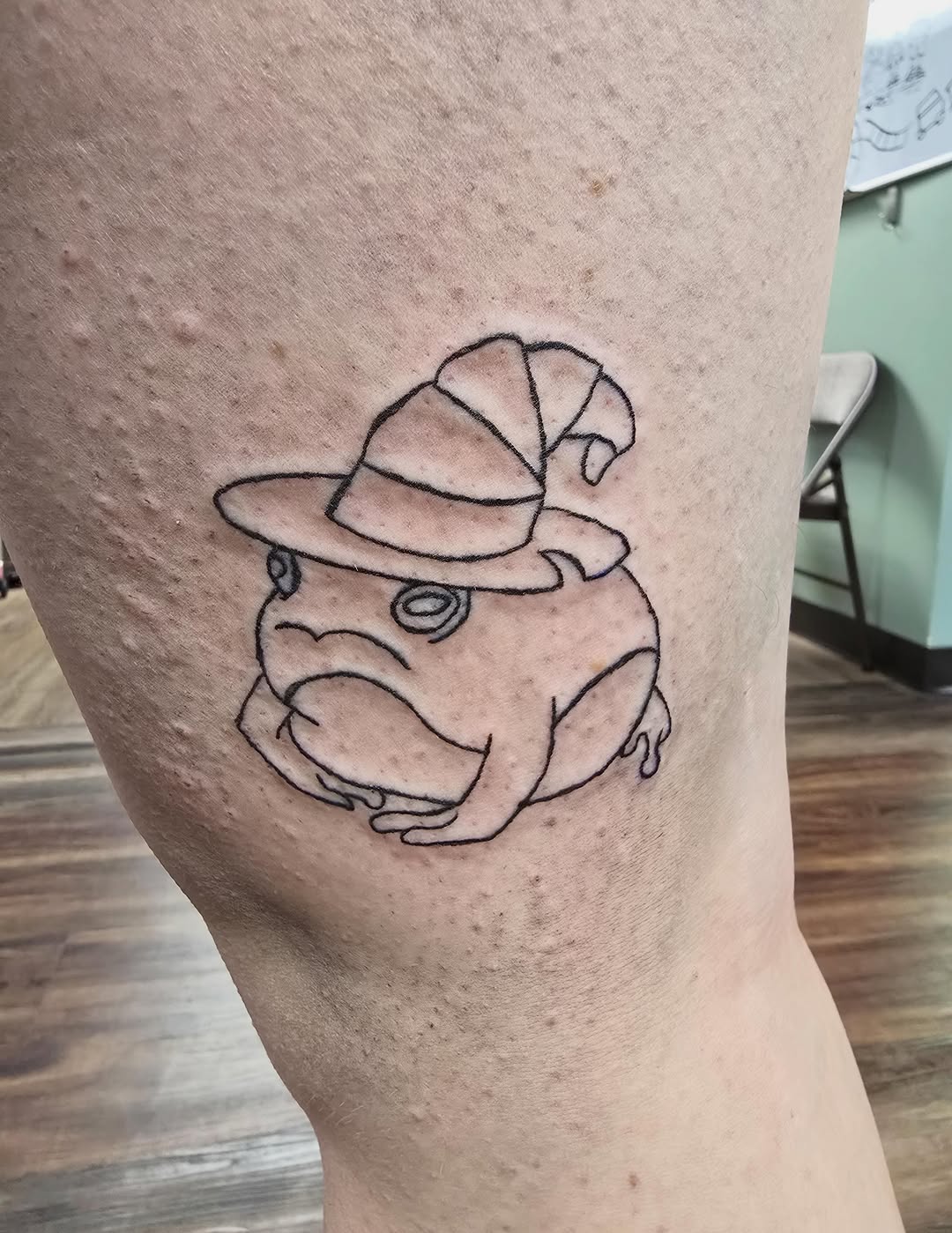 Frog wearing a witch hat American traditional tattoo on the thigh by Catherine B