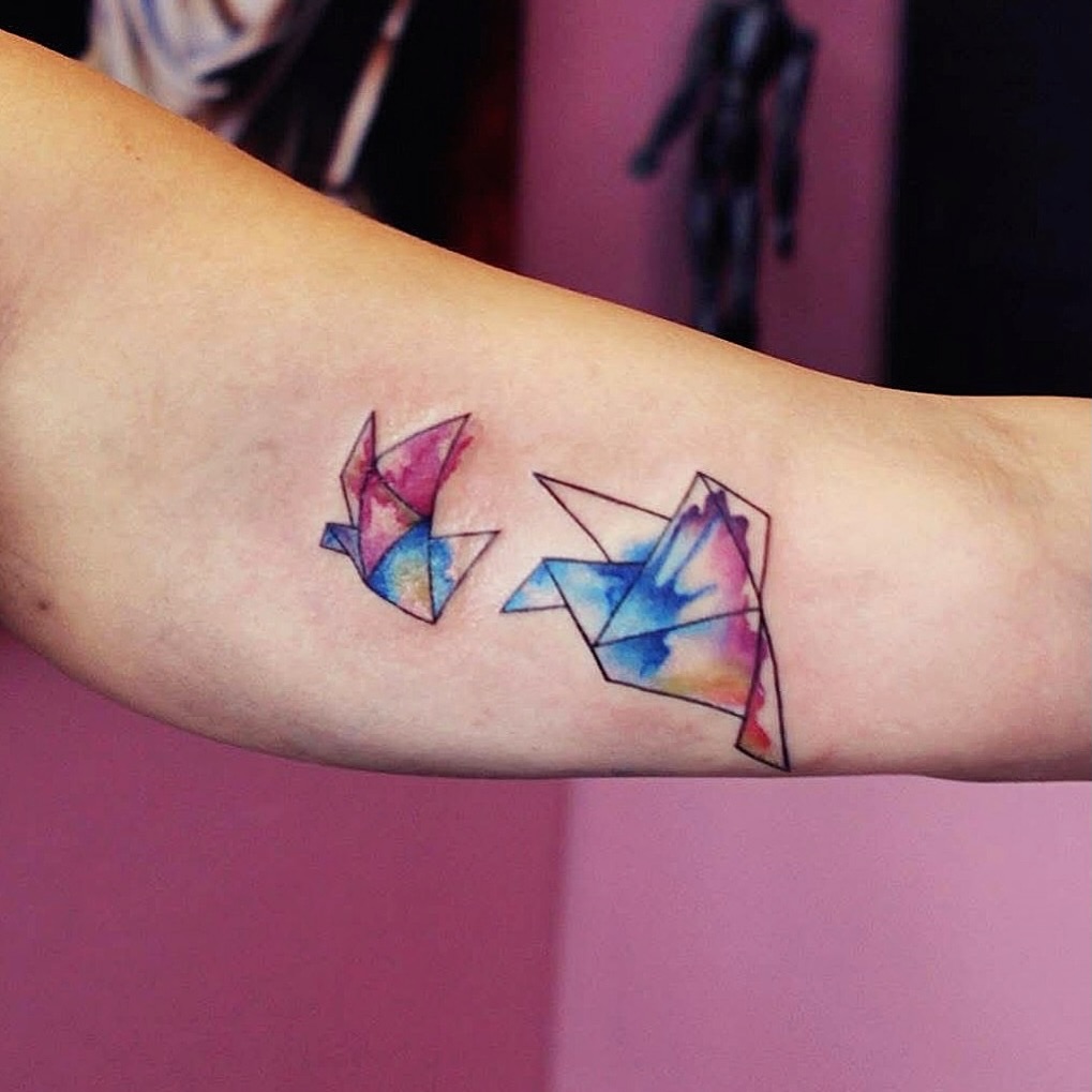 Origami birds watercolor tattoo on the forearm by Yana Aizen