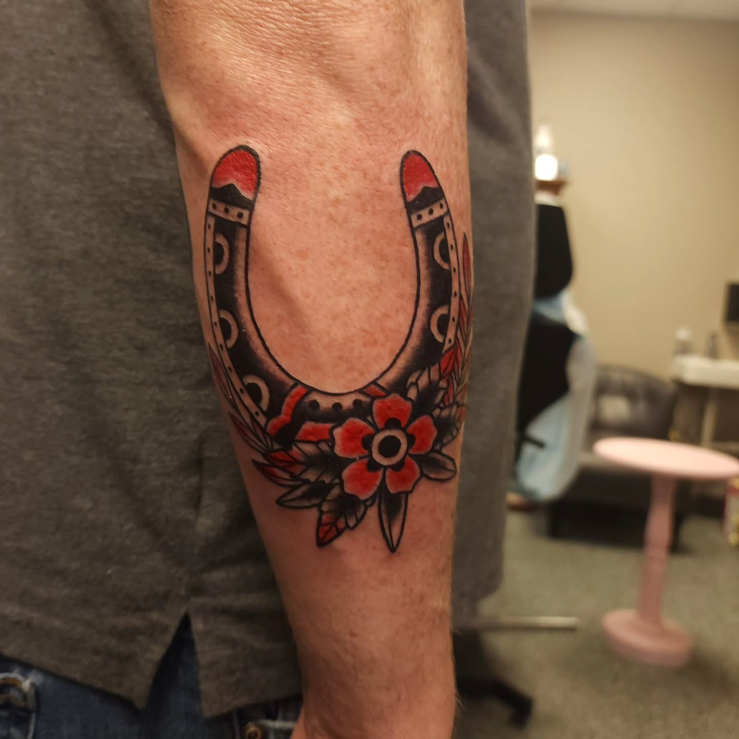 Horseshoe with floral ornament American traditional tattoo on the forearm by xavia