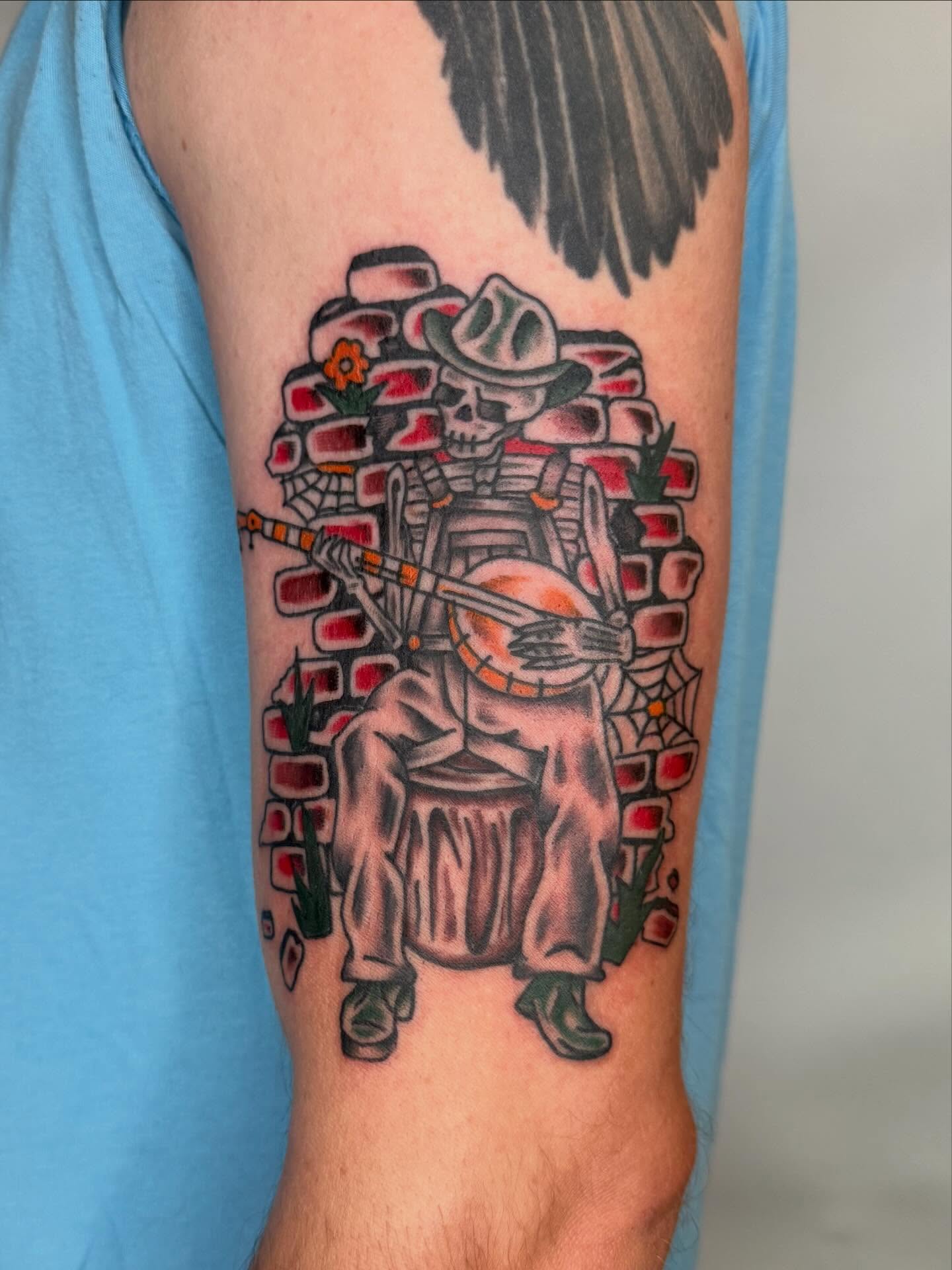 Skeleton playing banjo American traditional tattoo on the forearm by Jacqui Rose