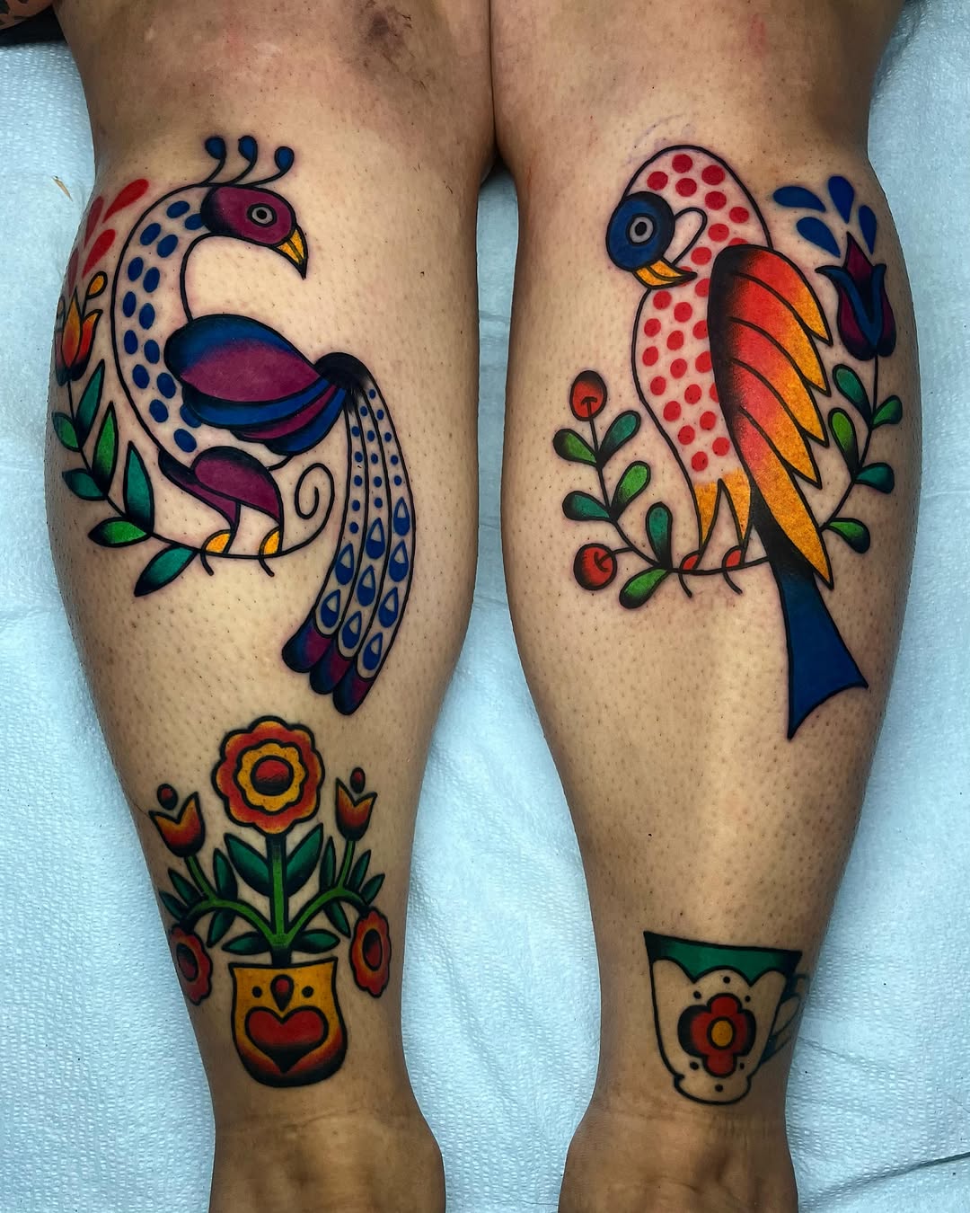 Bird and floral motifs American traditional tattoo on the leg by Em Adkins