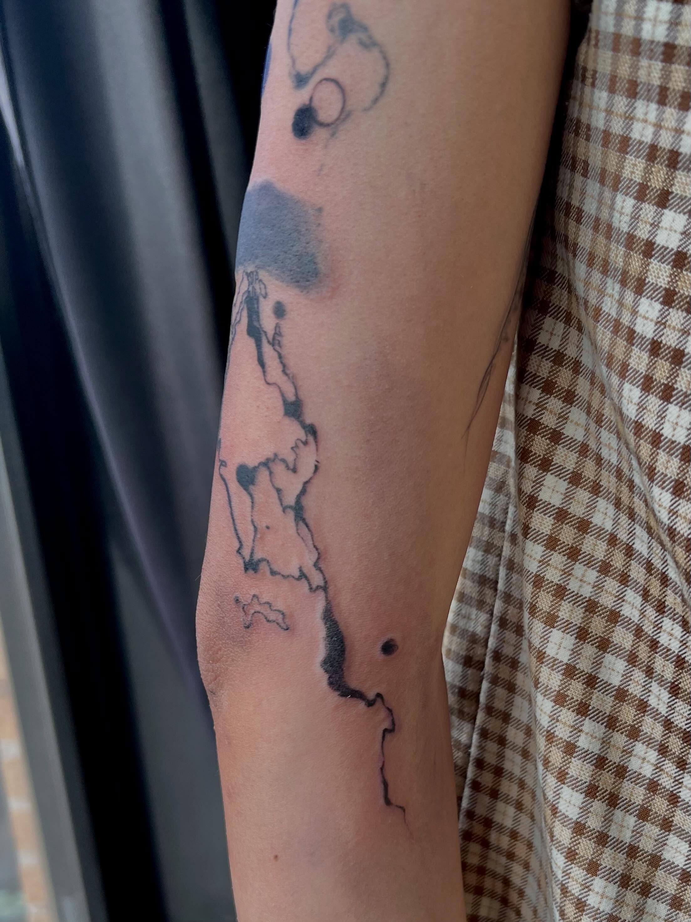 Abstract landscape dotwork tattoo on the forearm by Haiiitattoo