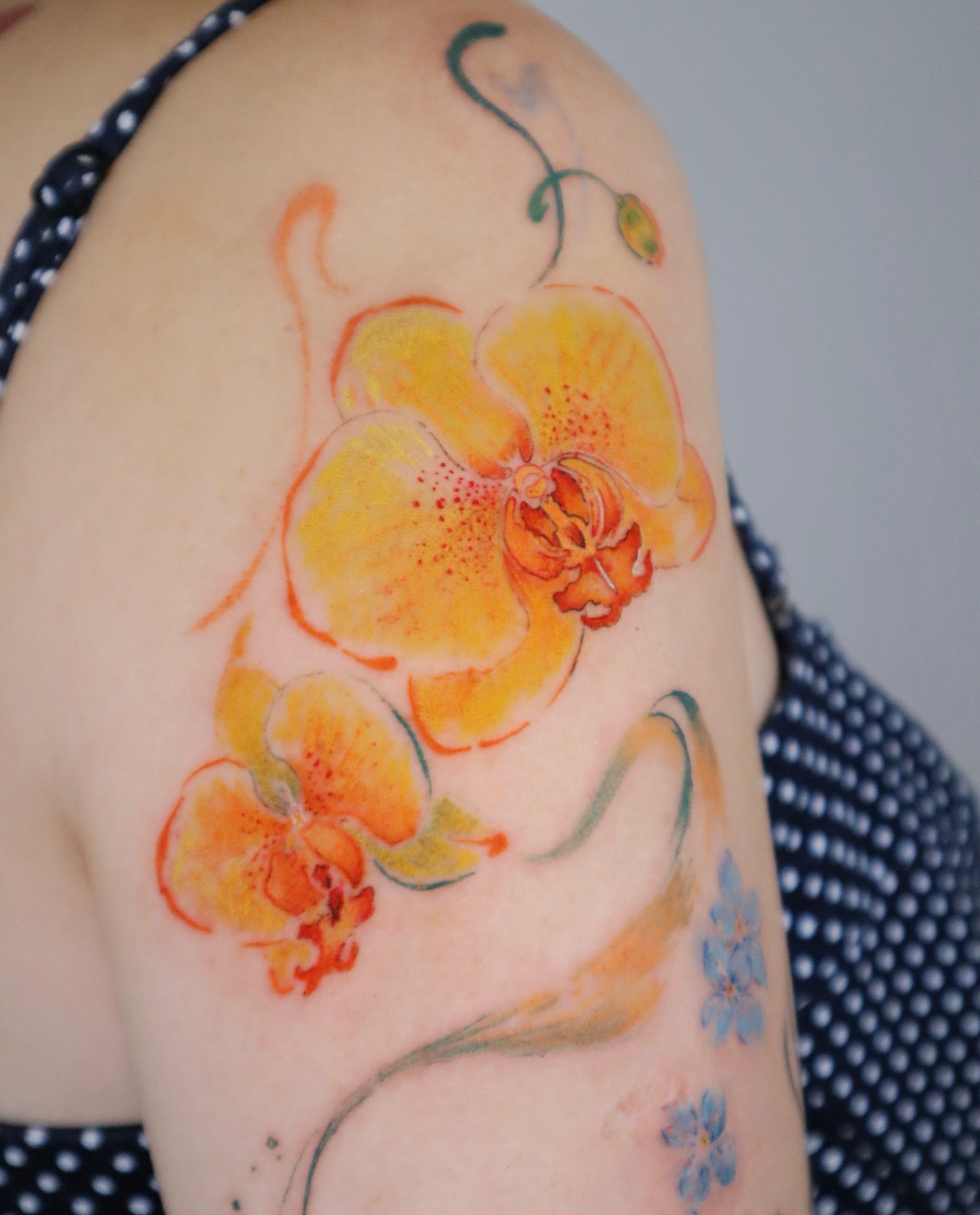 Yellow orchid watercolor tattoo on the shoulder by Sylvia｜思岐, Vancouver, British Columbia