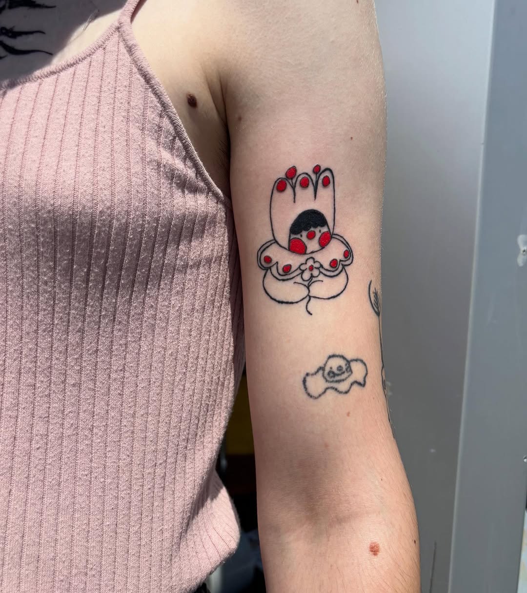 Abstract character with red dots ignorant tattoo on the forearm by riley