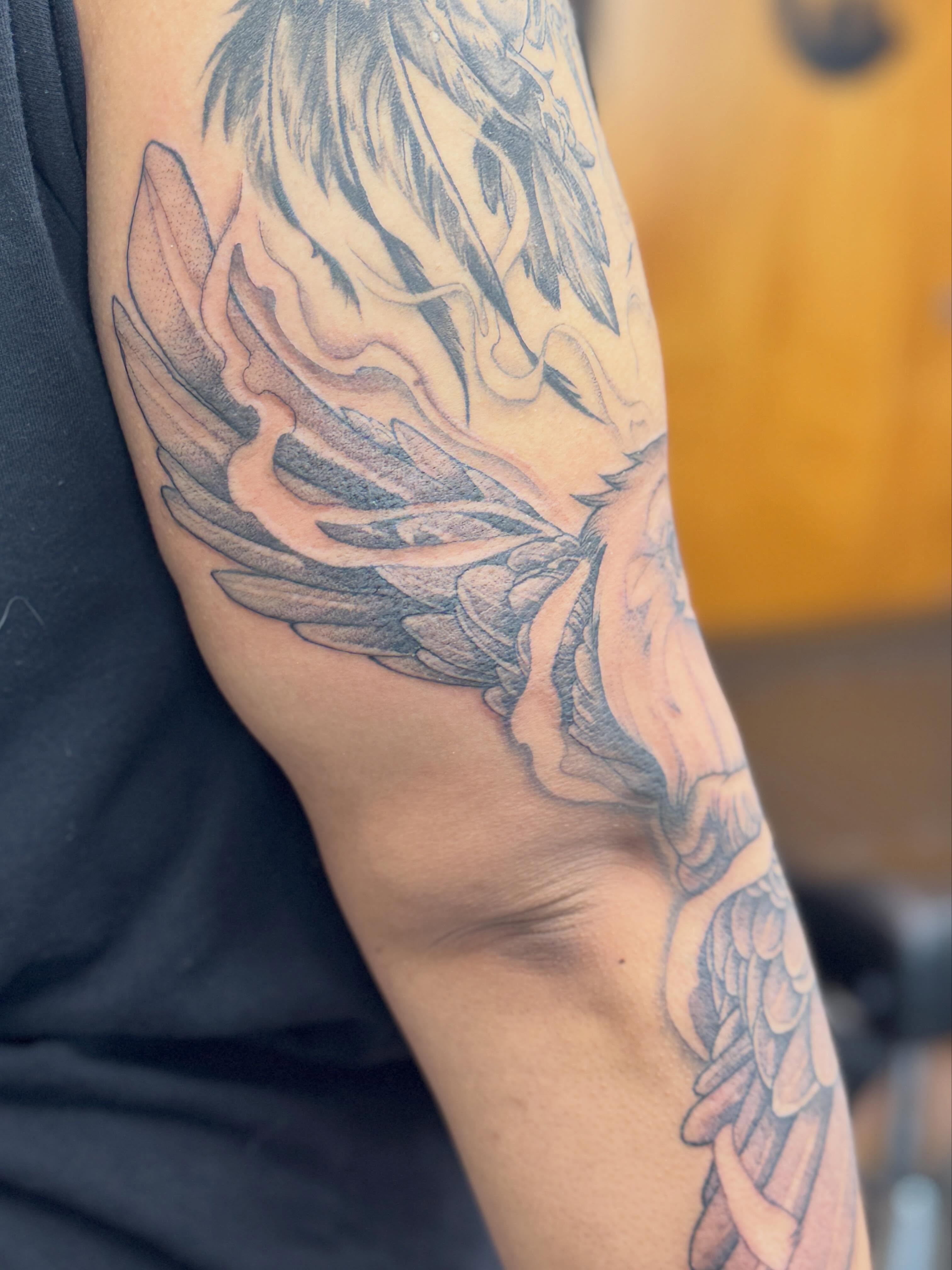 Winged creature black and grey tattoo on the forearm by Rebecca Rose