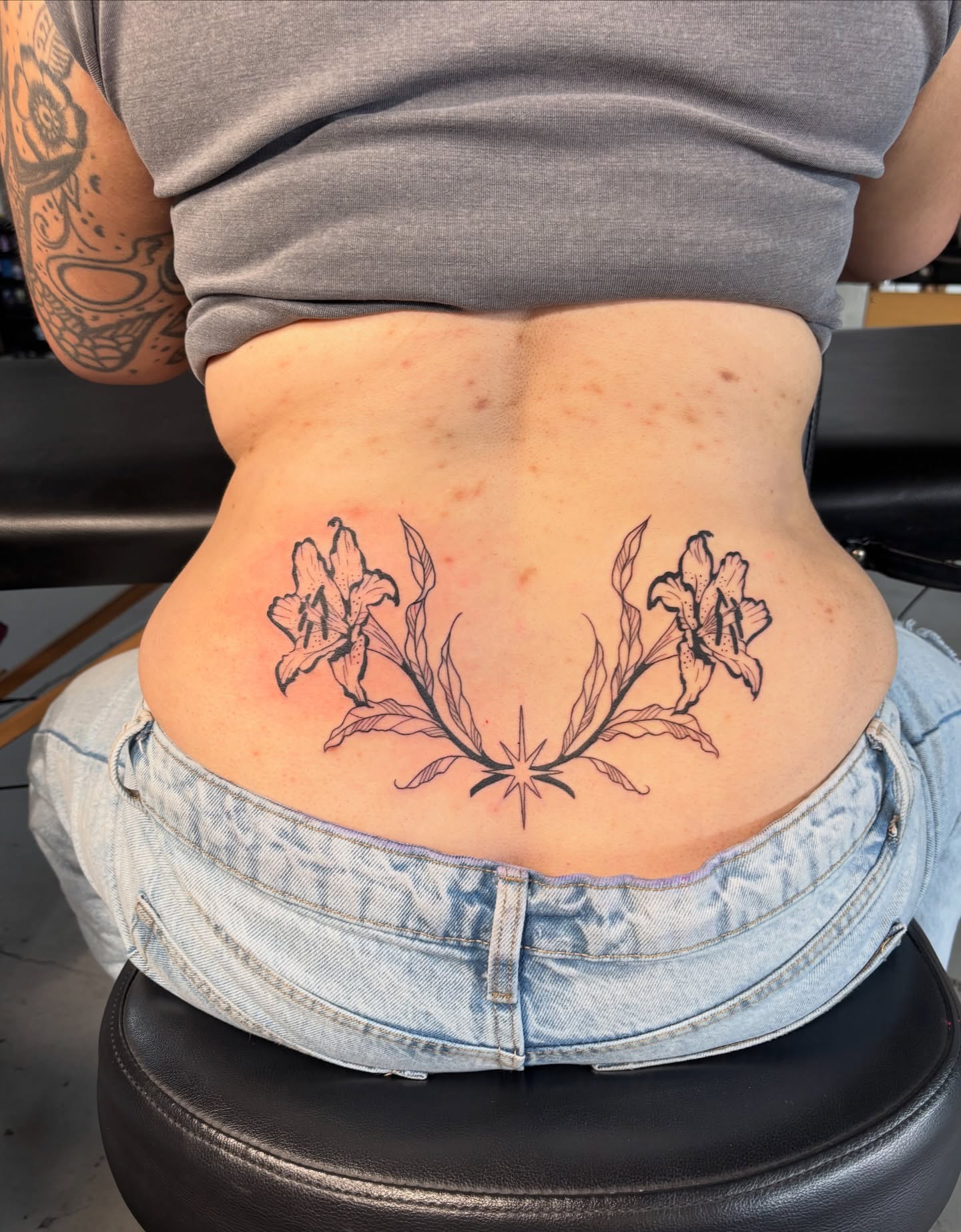 Flowers and star black and grey tattoo on the back by Kate Behr 🌱