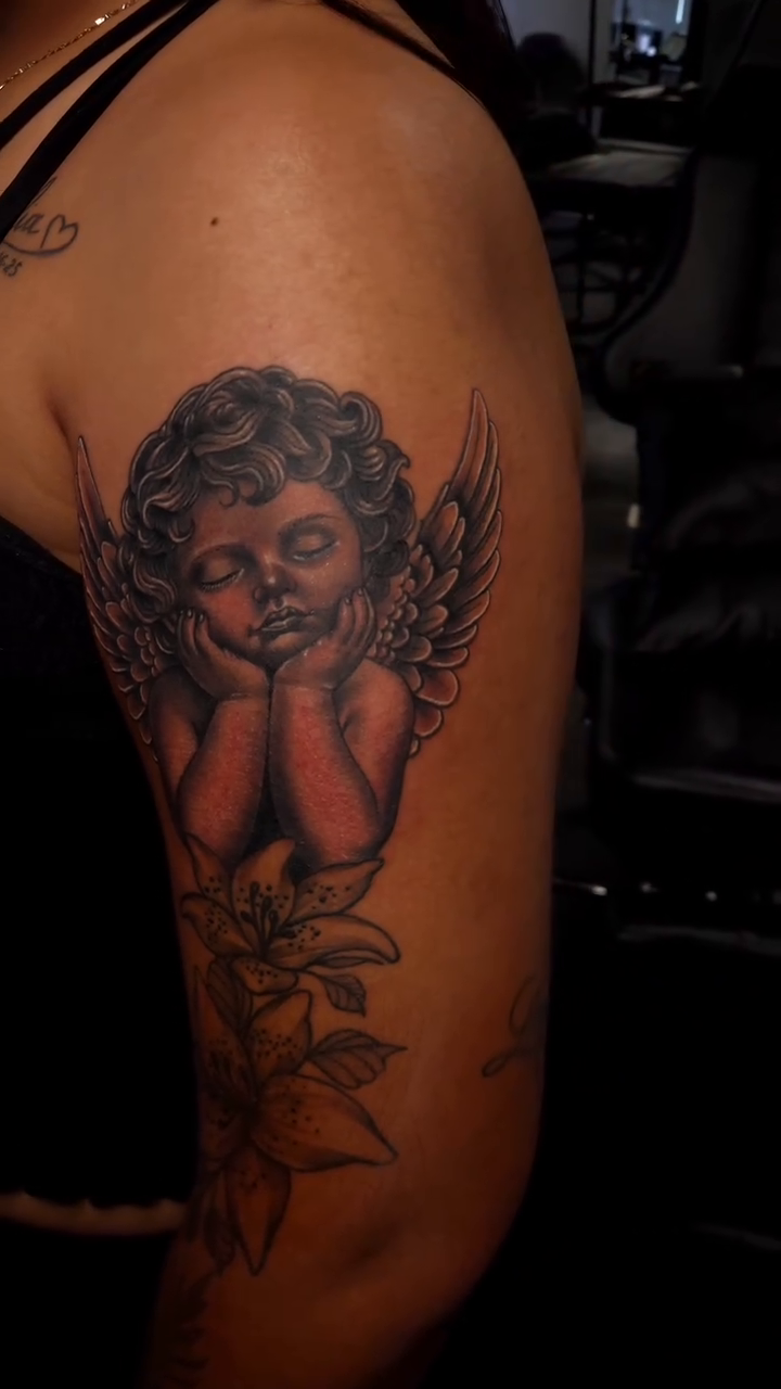 Cherub with flowers realism tattoo on the upper arm by Joey Vinci, Phoenix, Arizona