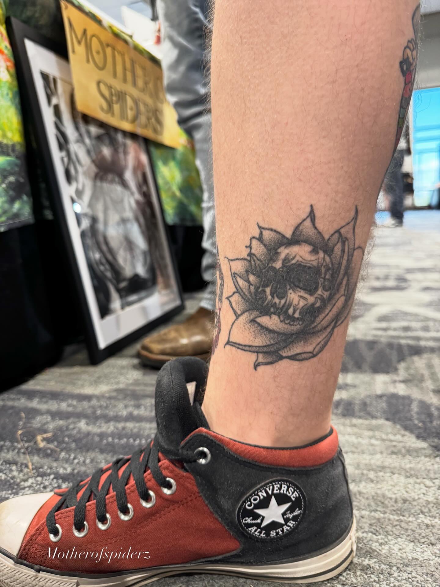 Skull and lotus black and grey tattoo on the calf by Alyssa Garza