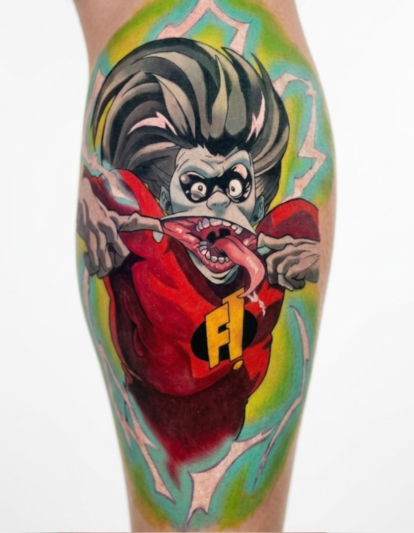 Character with tongue out new school tattoo on the forearm by Tattoo Bam Bam