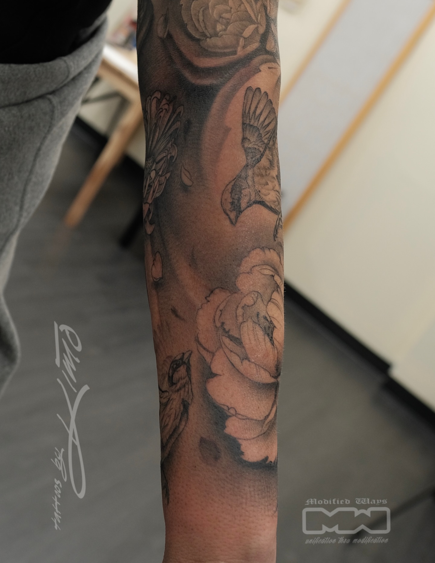 Birds and flowers realism tattoo on the forearm by Kansas City tattoo artist