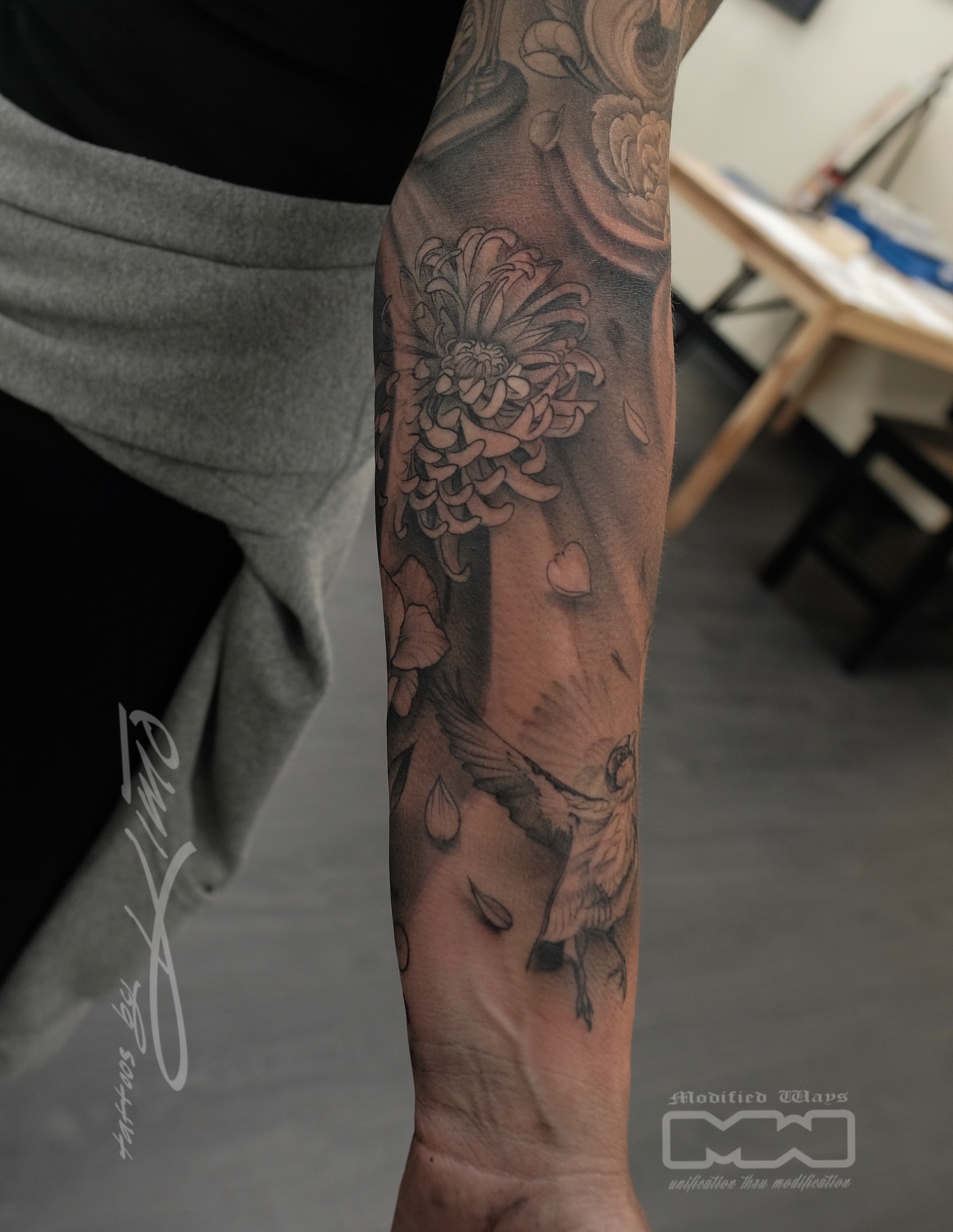 Chrysanthemum and bird realism tattoo on the forearm by Kansas City tattoo artist