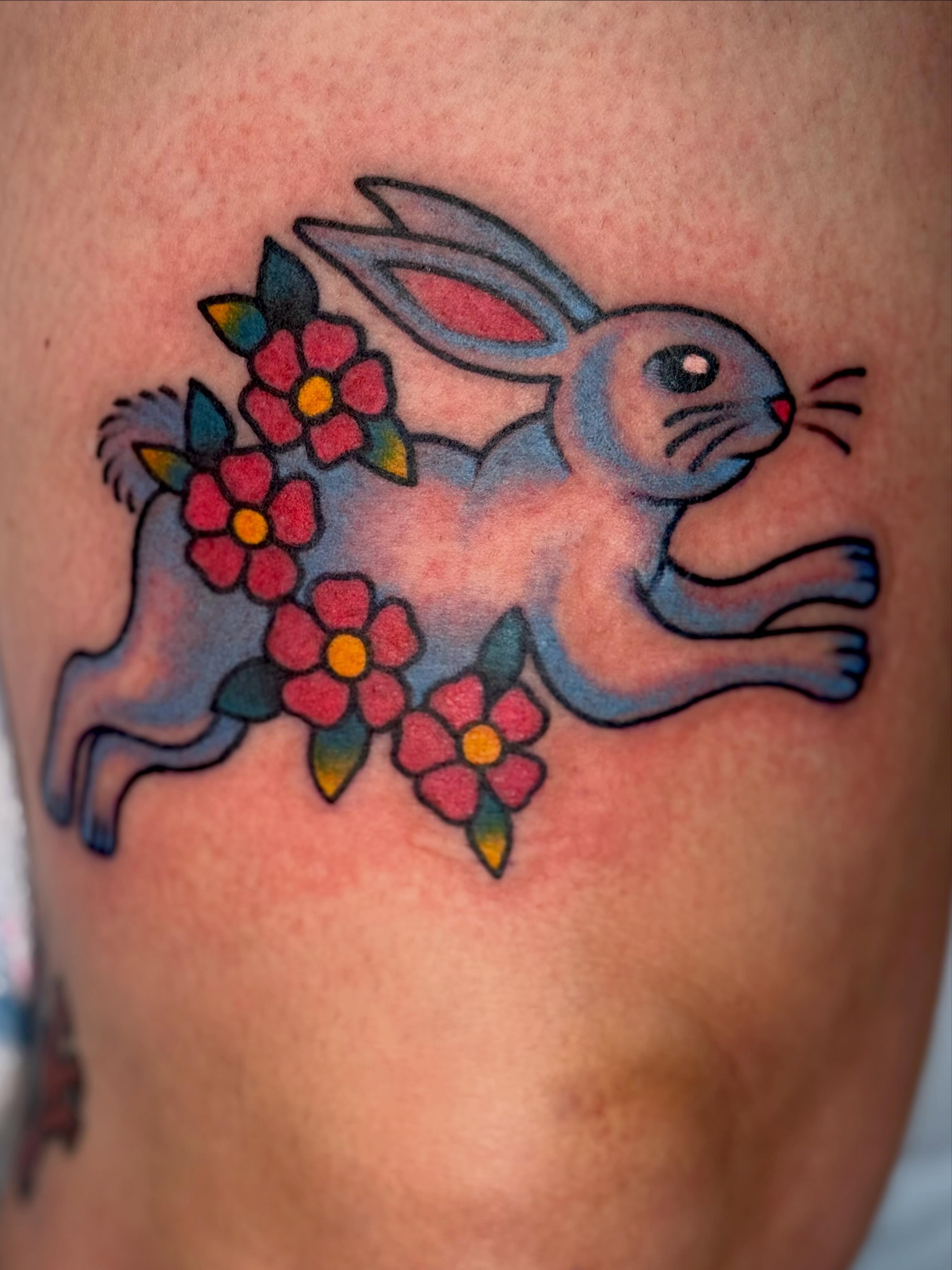 Rabbit with flowers American traditional tattoo on the thigh by KevinBetsch
