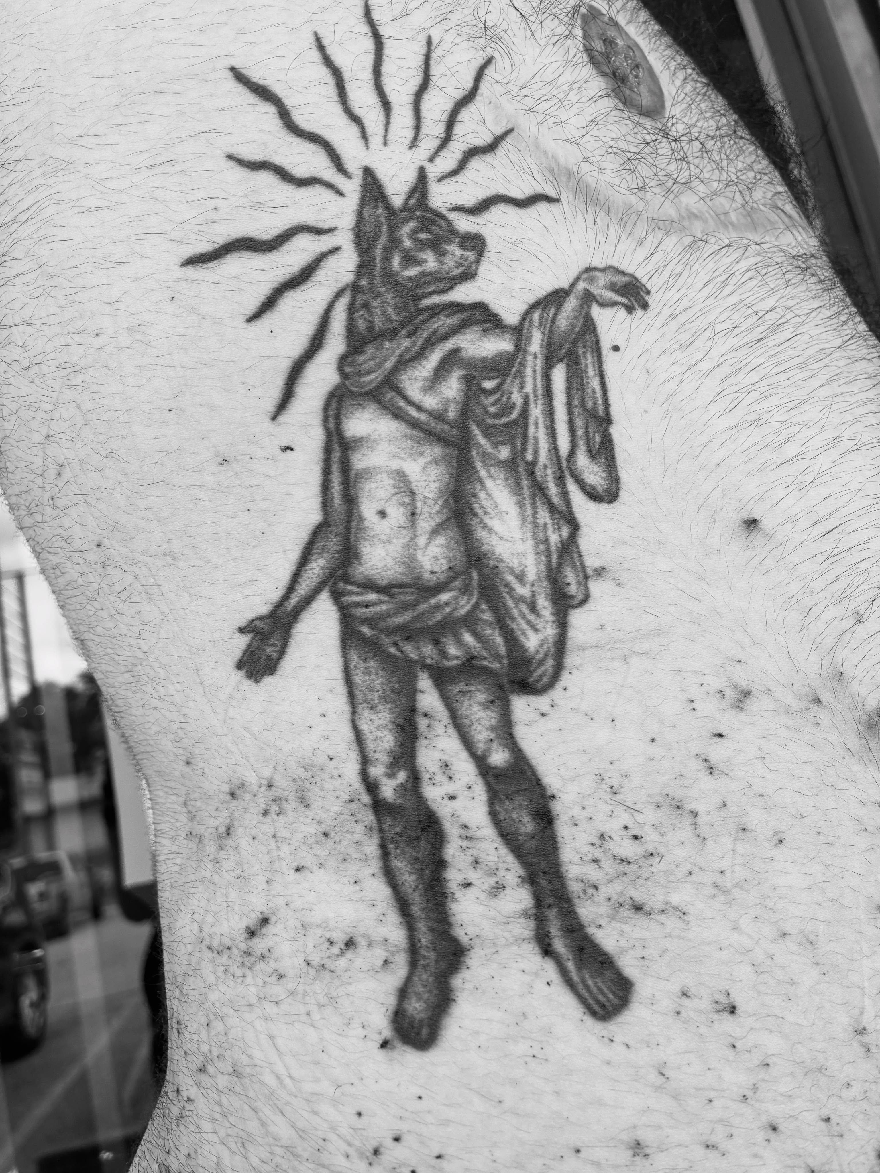 God-like figure with dog head black and grey tattoo on the thigh by Zachary R Bobkoff