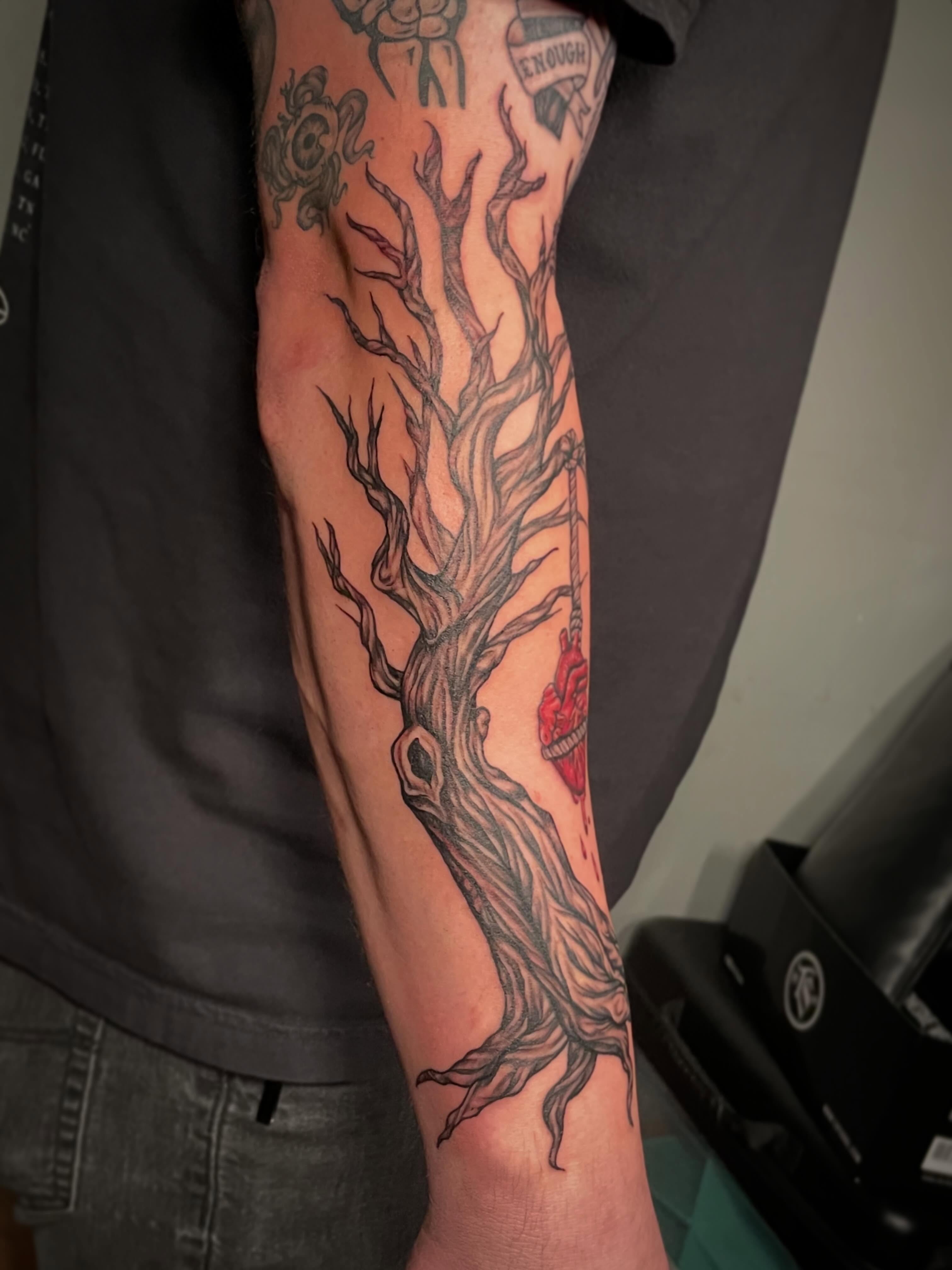 Tree with heart dark realism tattoo on the forearm by Hannah Copeskey