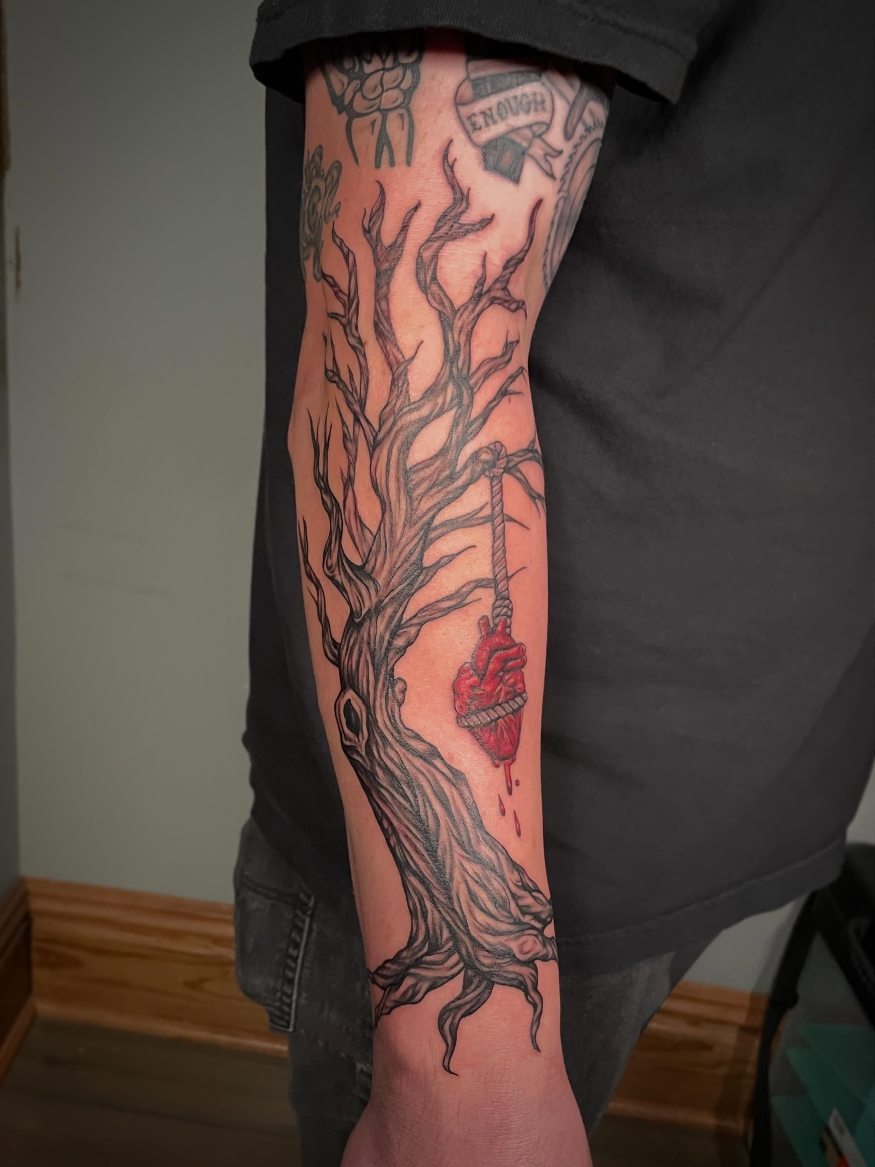 Heart and tree dark realism tattoo on the forearm by Hannah Copeskey