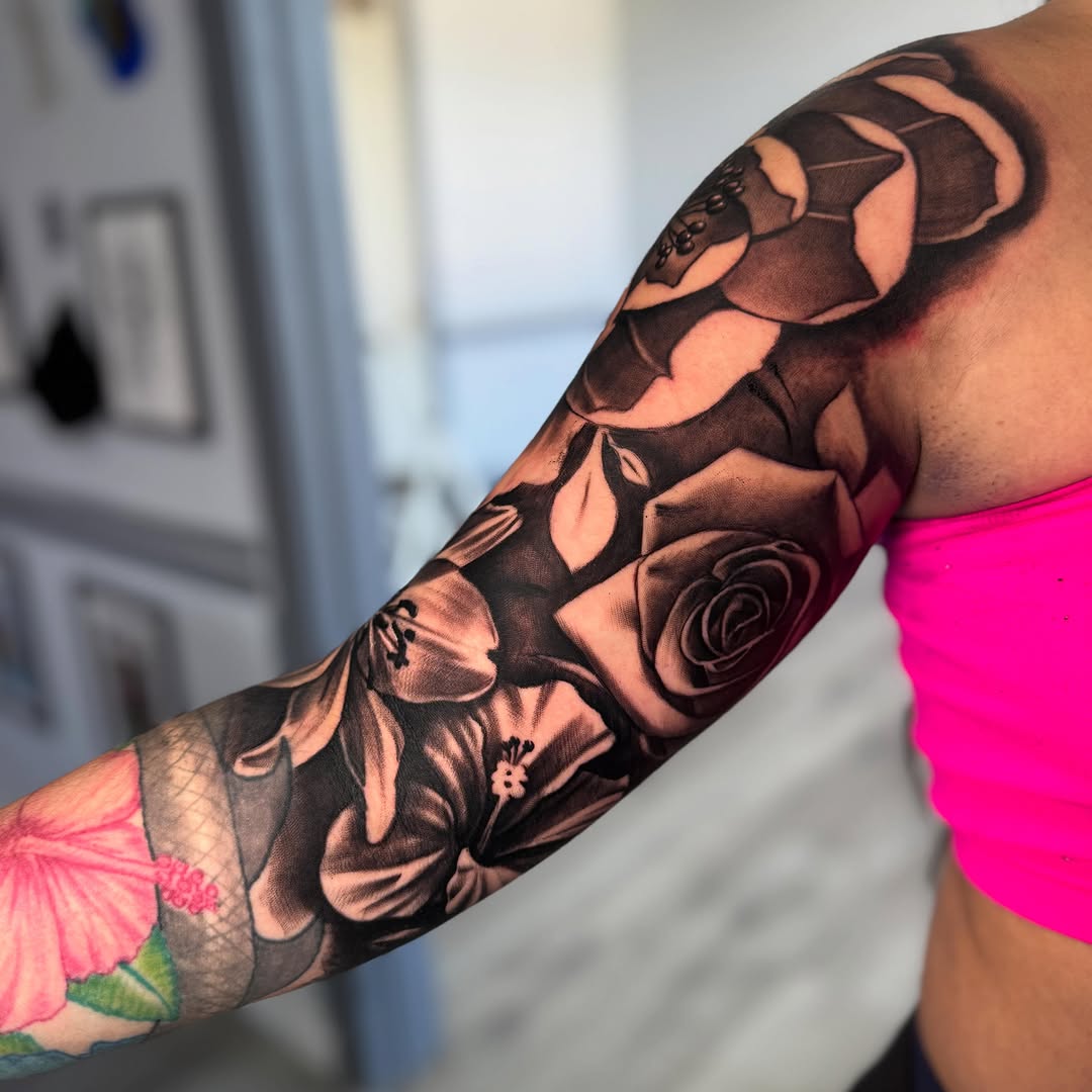 Roses and lilies dotwork tattoo on the upper arm by Isiah Hall, Whittier, California