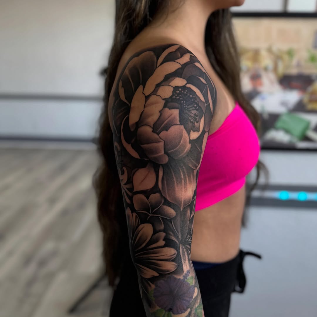 Floral sleeve realism tattoo on the upper arm by Isiah Hall, Whittier, California