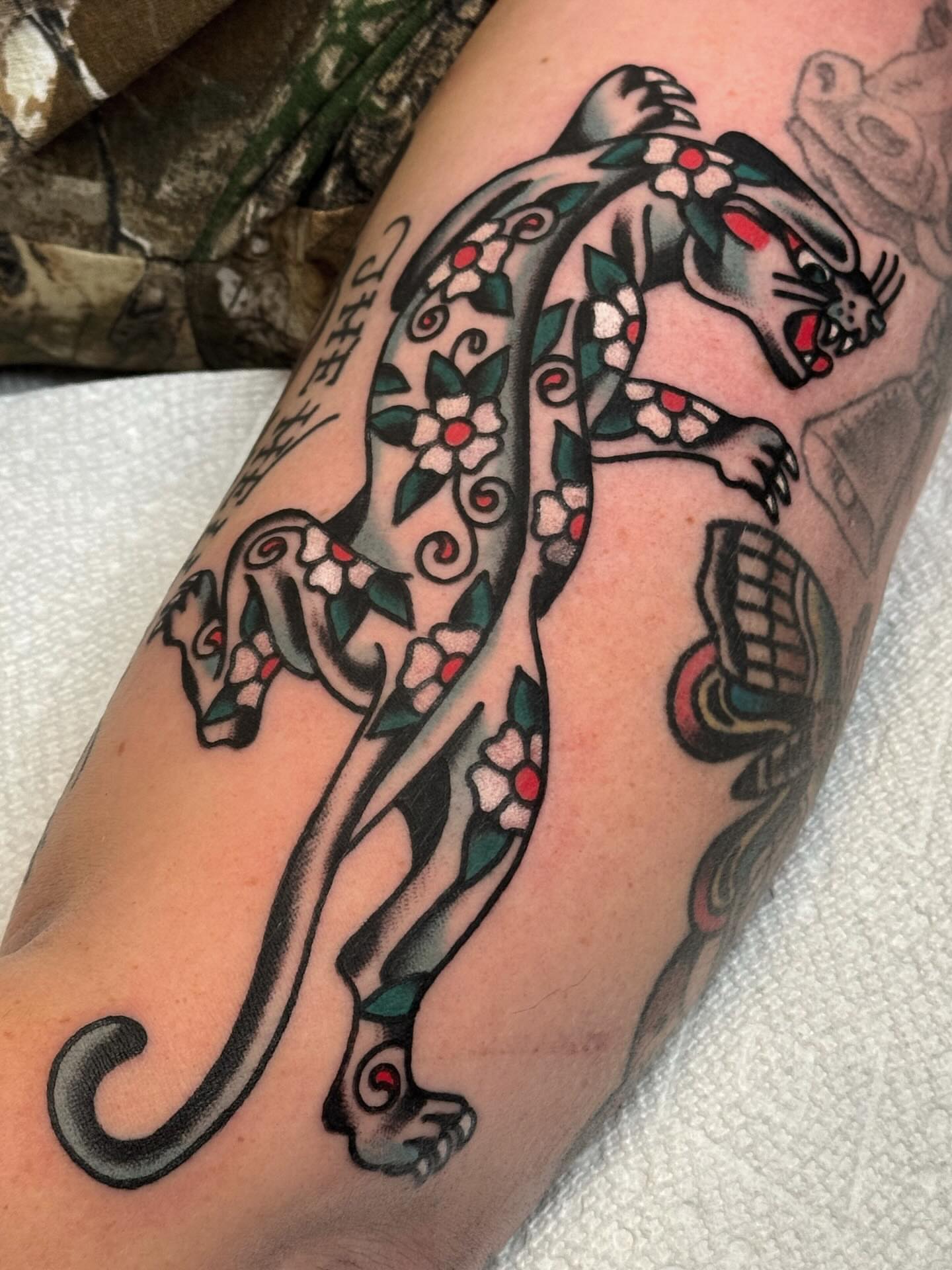 Panther with floral patterns American traditional tattoo on the forearm by Bryce Shearer