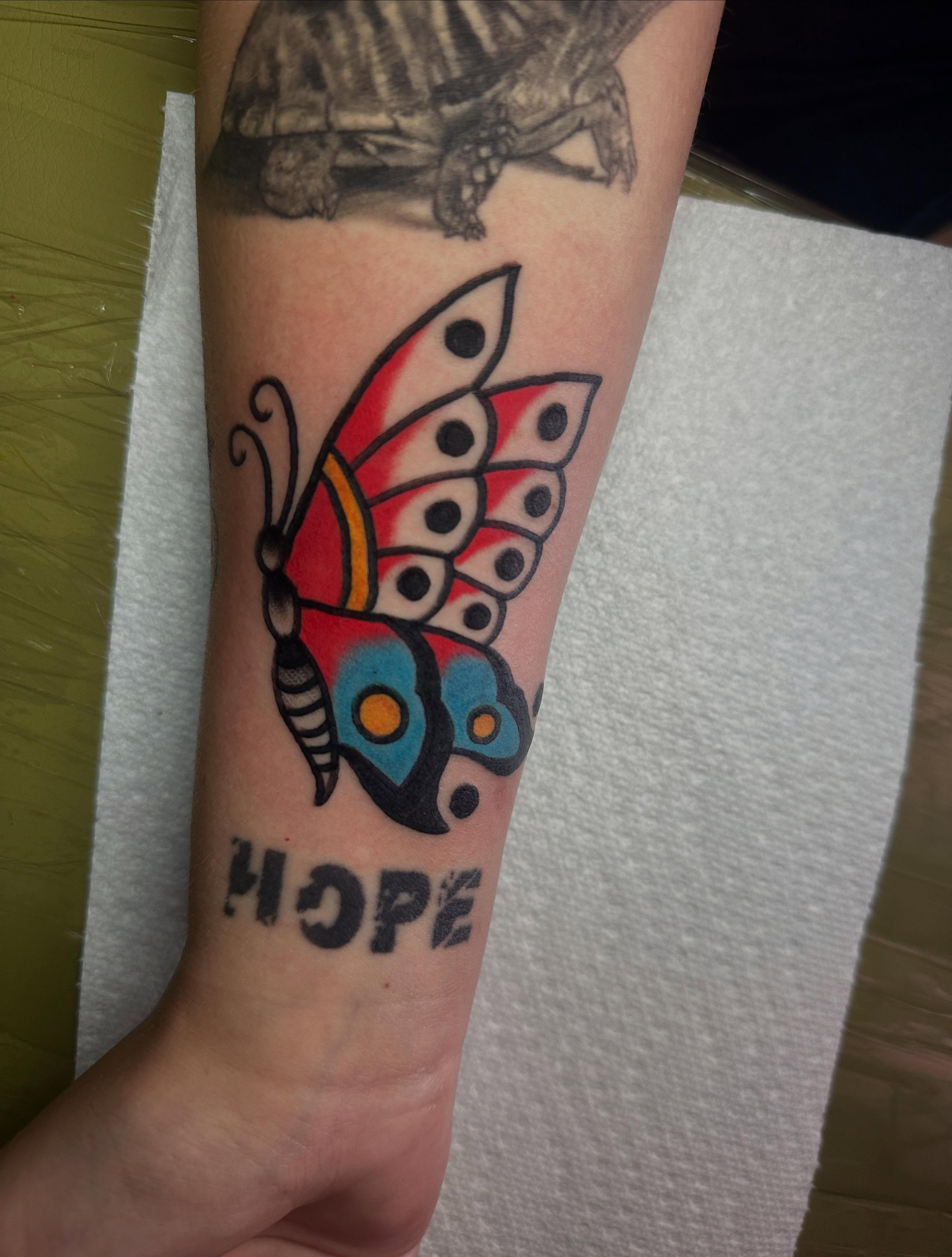 Butterfly American traditional tattoo on the forearm by Chris Bishop