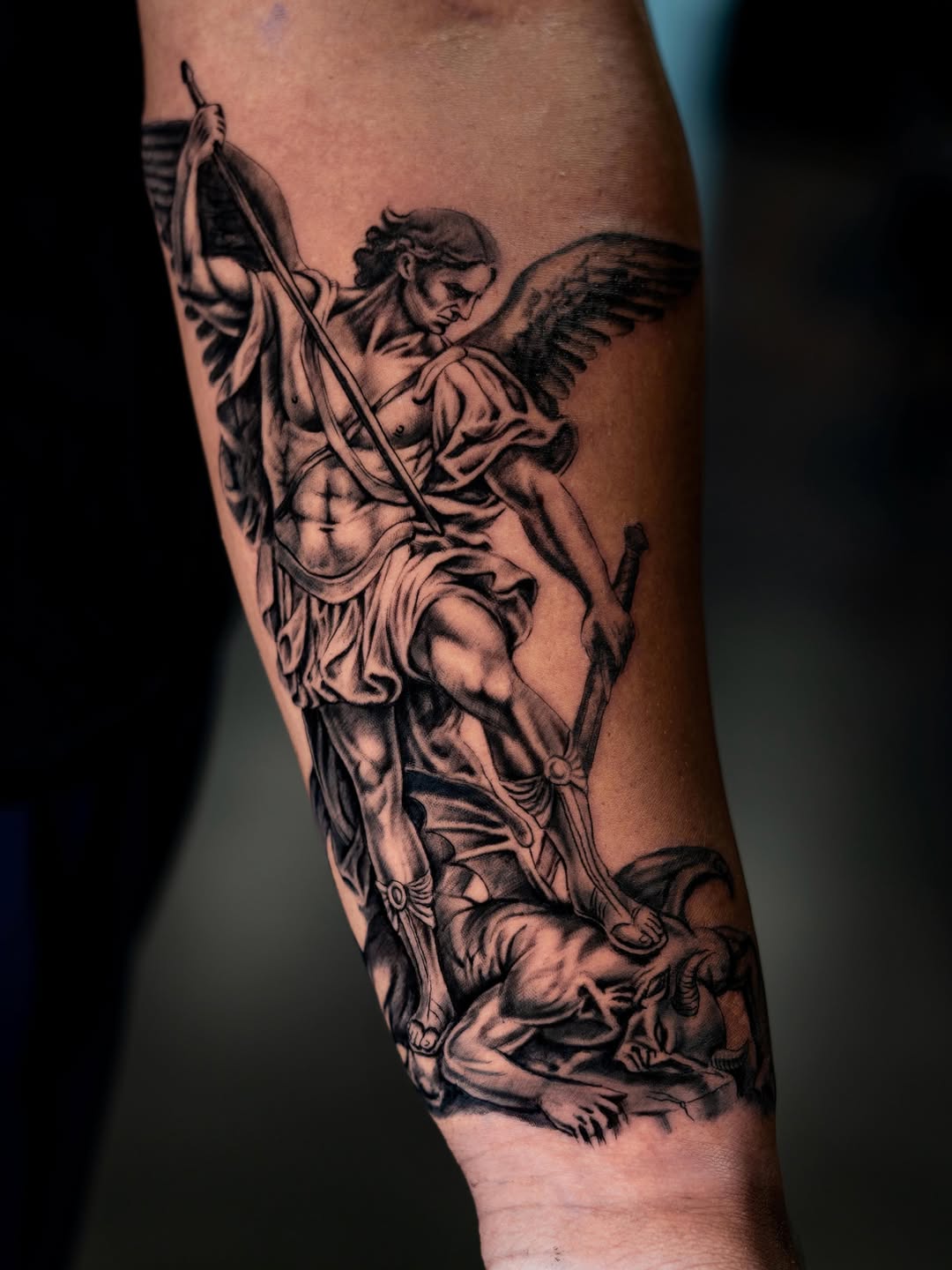 Archangel Michael defeating a demon realism tattoo on the forearm by Charlotte Tattoo Artist