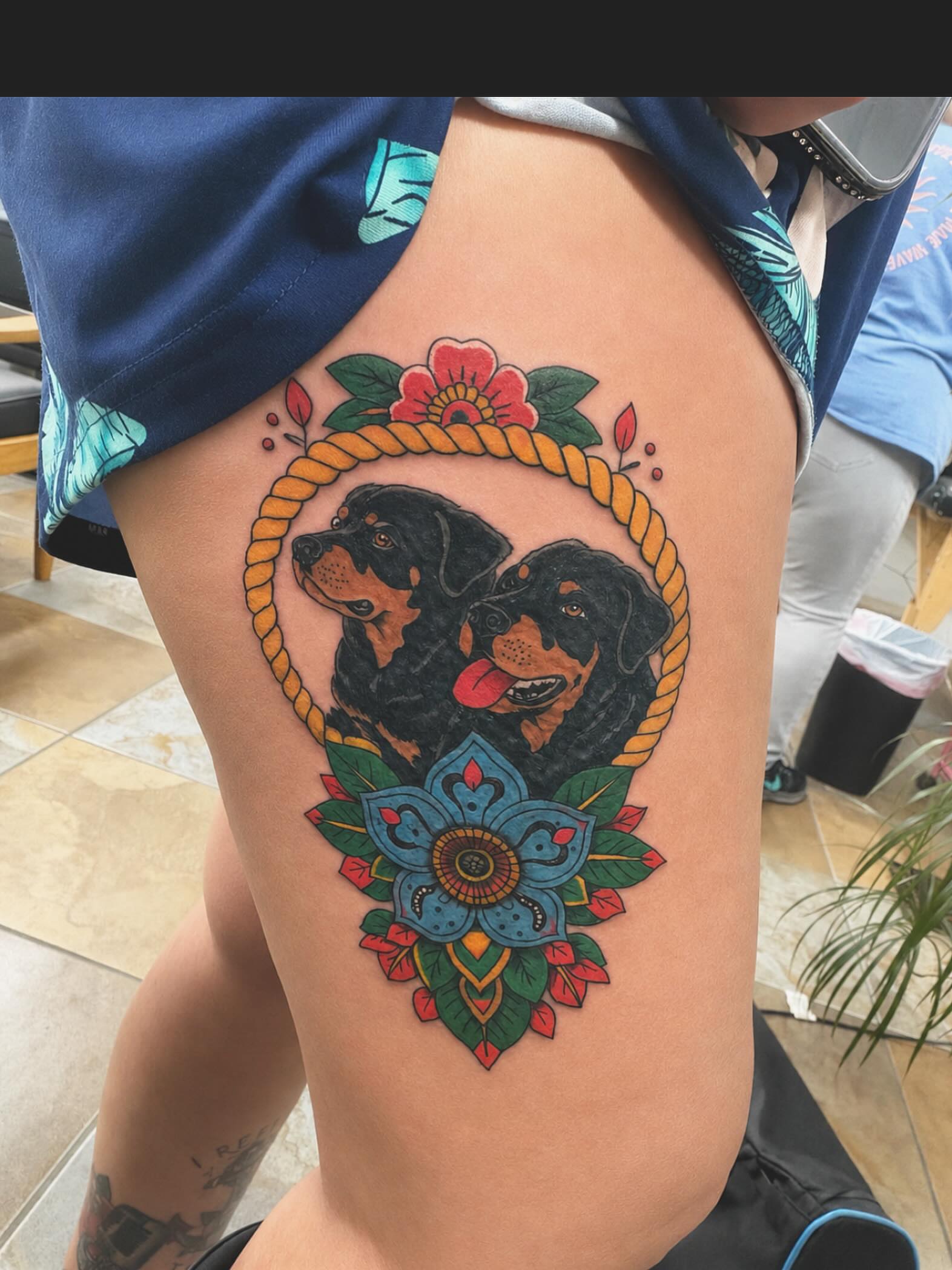 Two dogs in a rope American traditional tattoo on the thigh by Stoney
