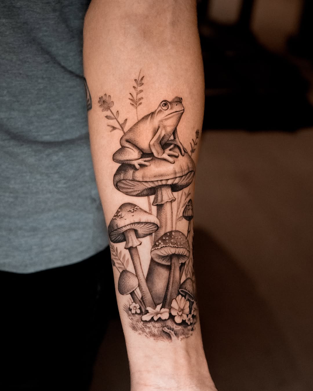 Frog on mushrooms surrealism tattoo on the forearm by Mateo