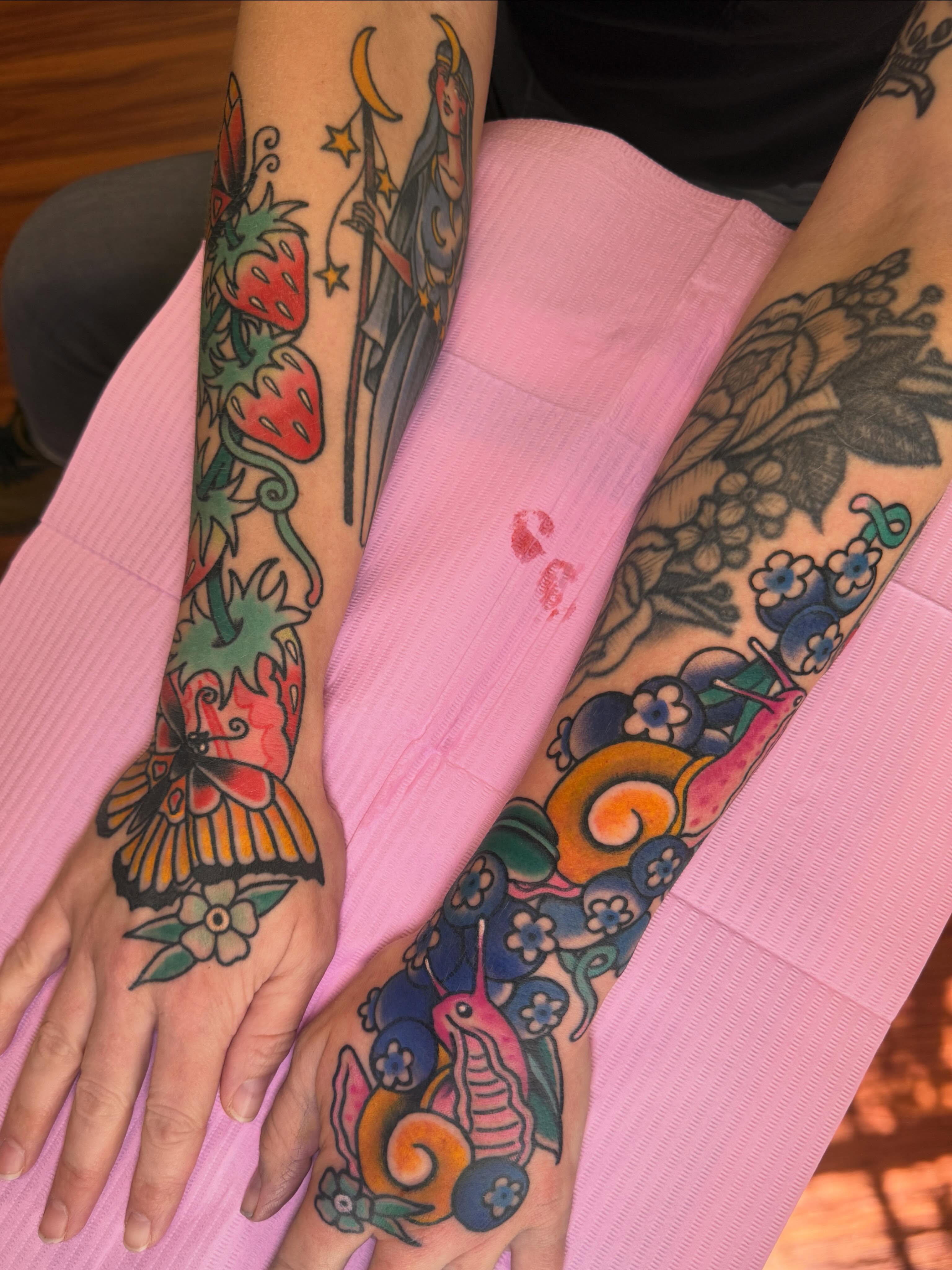 Strawberries and butterfly American traditional tattoo on the forearm by Cassie O'Neal DeBord