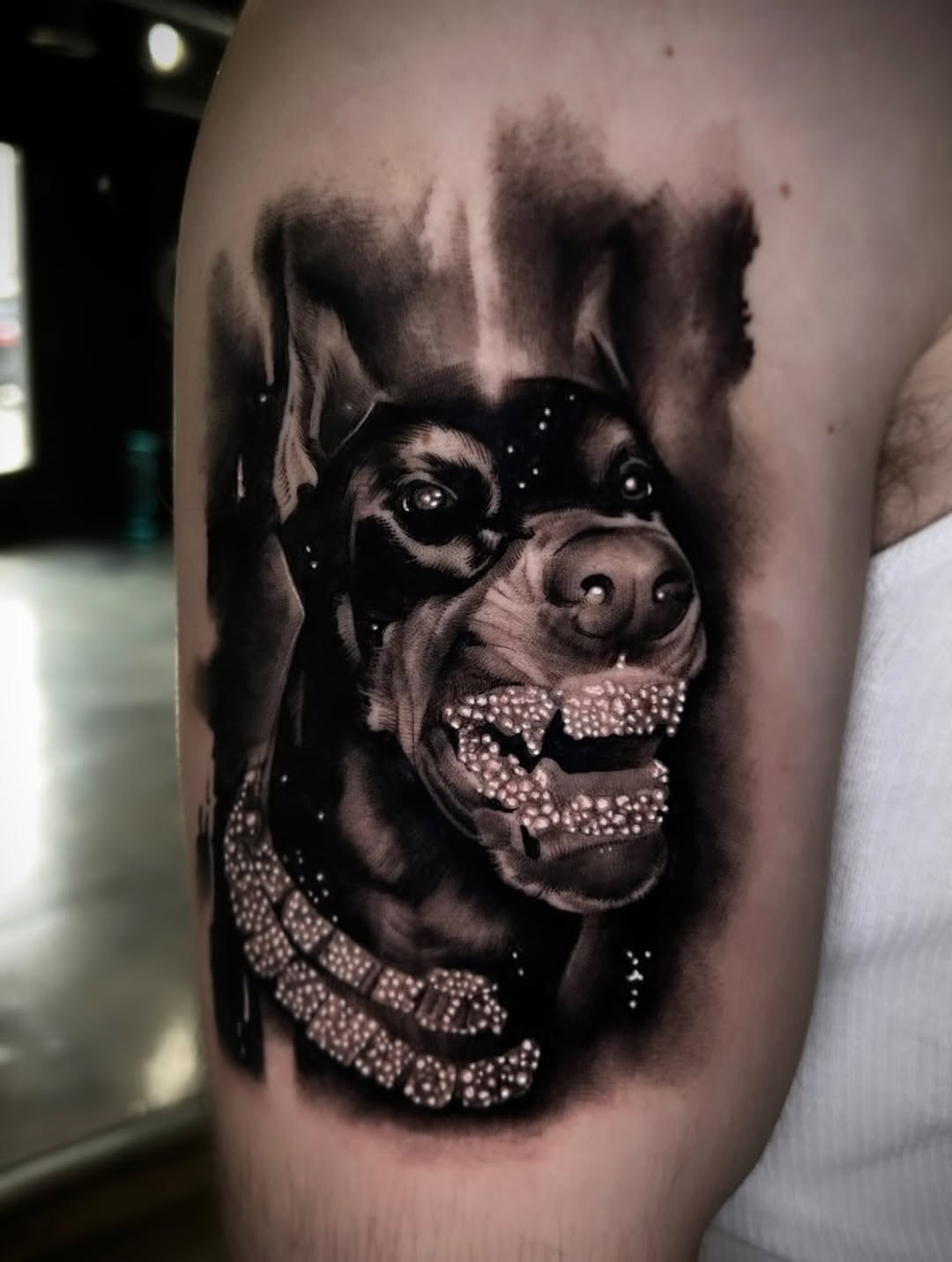 Doberman with diamond grill realism tattoo on the forearm by Dallas Corsmeier