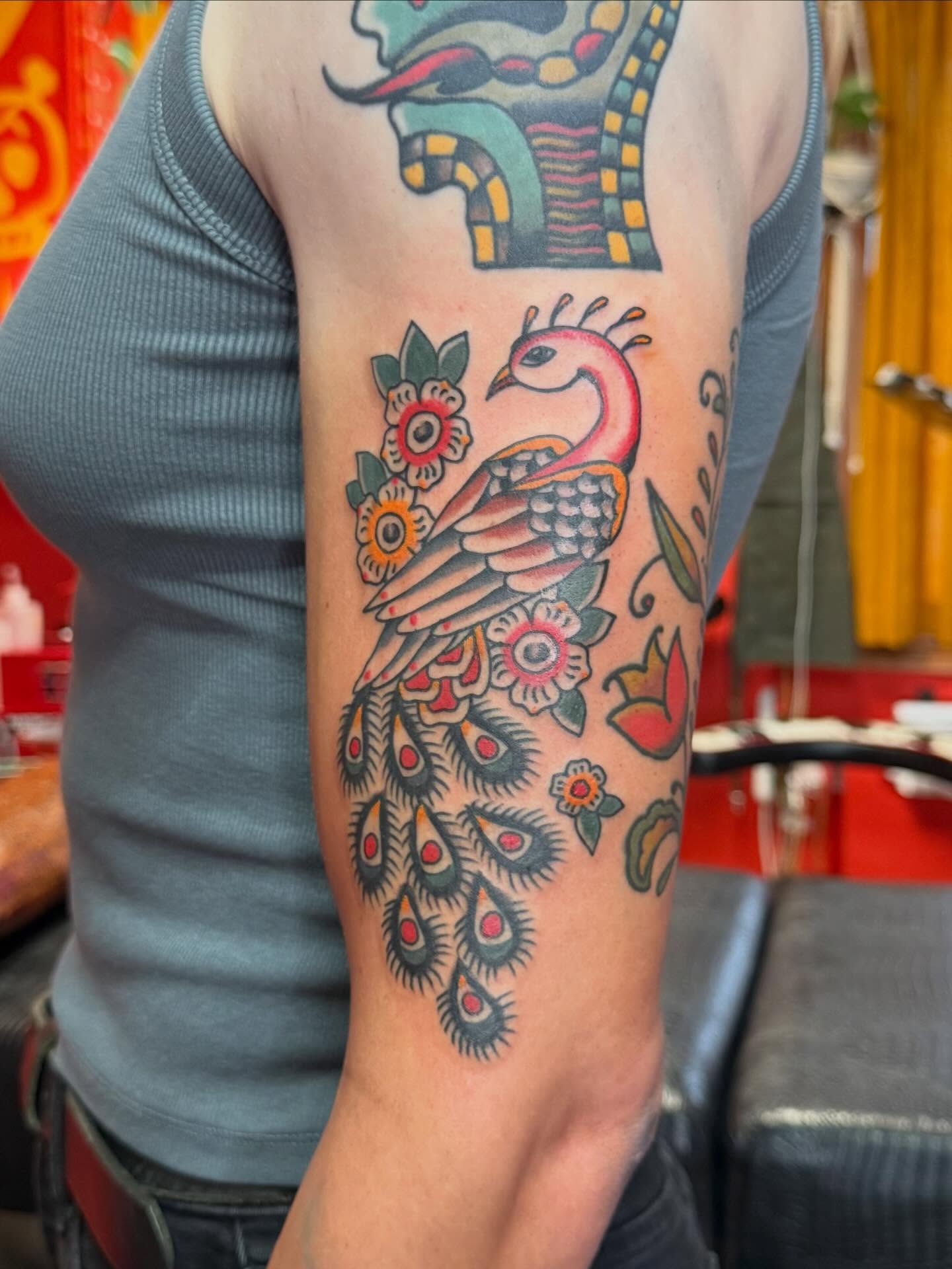 Peacock American traditional tattoo on the forearm by Jacqui Rose