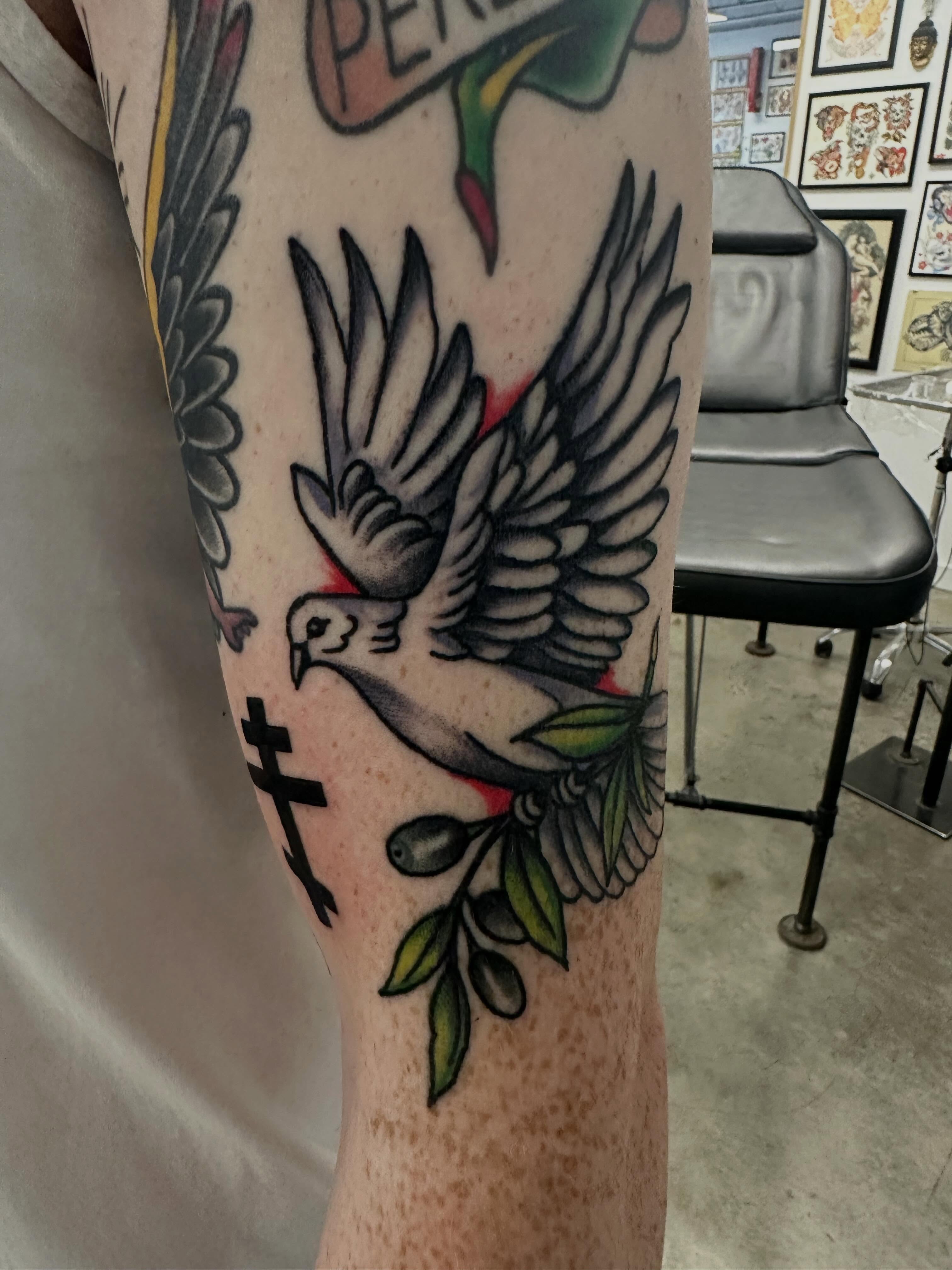 Dove with olive branch American traditional tattoo on the forearm by Vincent Merys