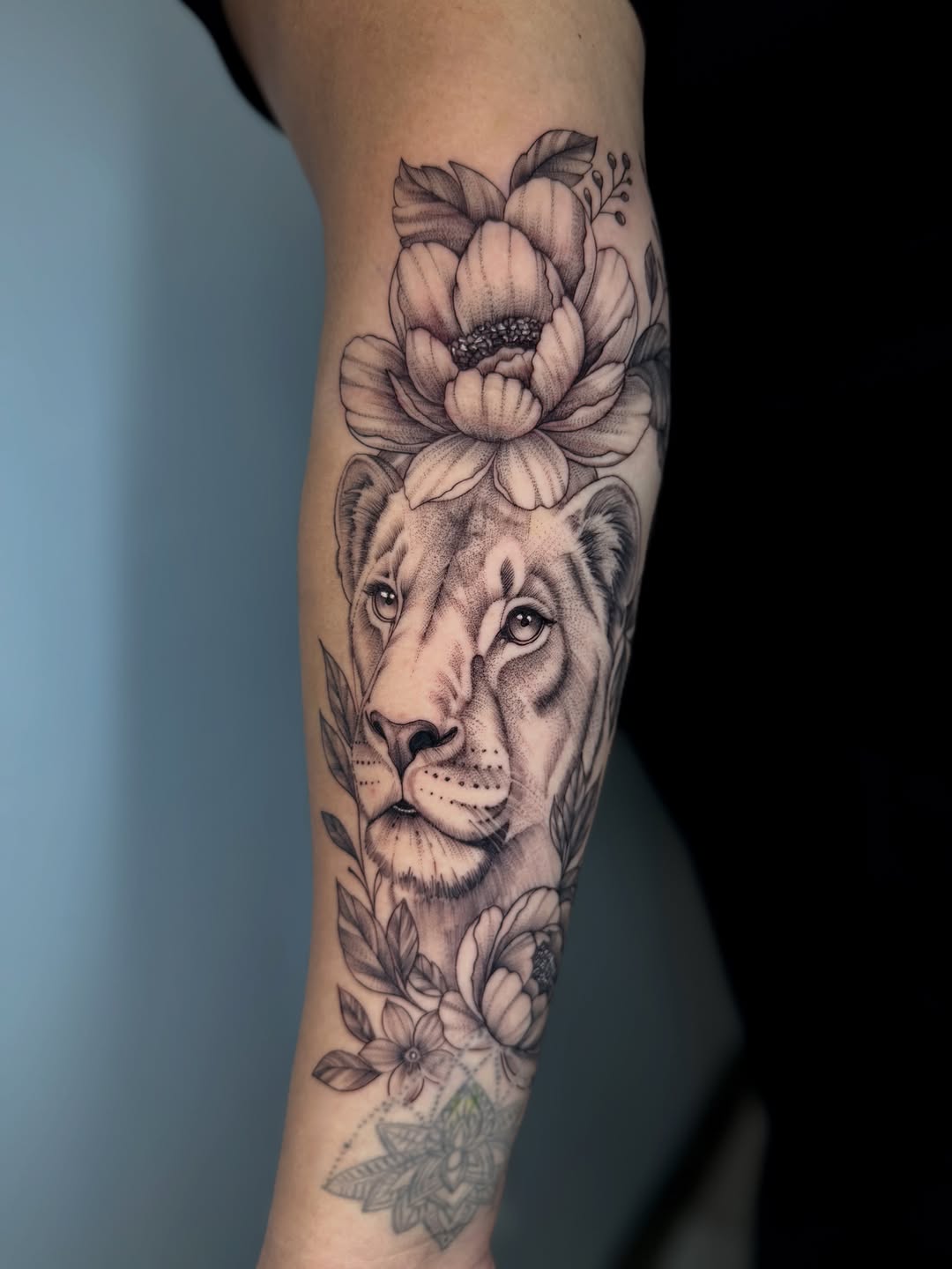 Lioness and flowers realism tattoo on the forearm by Adri Chavez