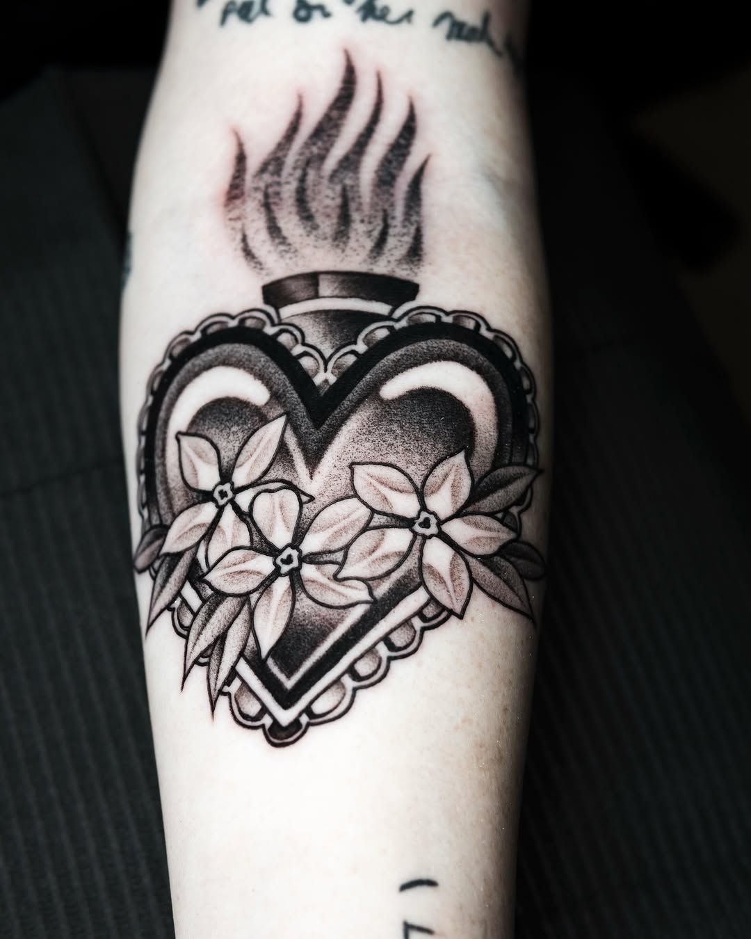 Heart with flames American traditional tattoo on the forearm by Danny Pando