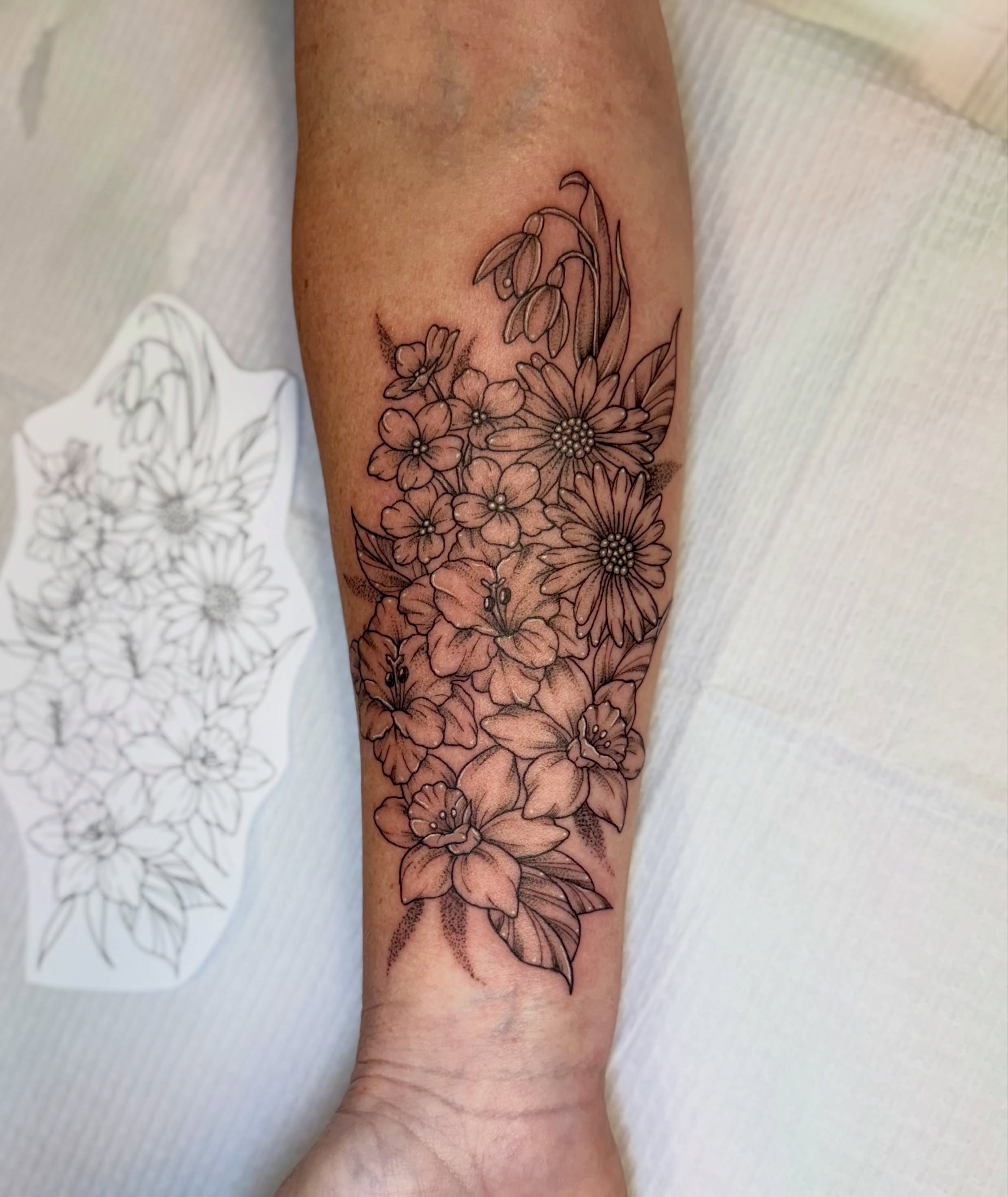 Floral bouquet black and grey tattoo on the forearm by McKenna