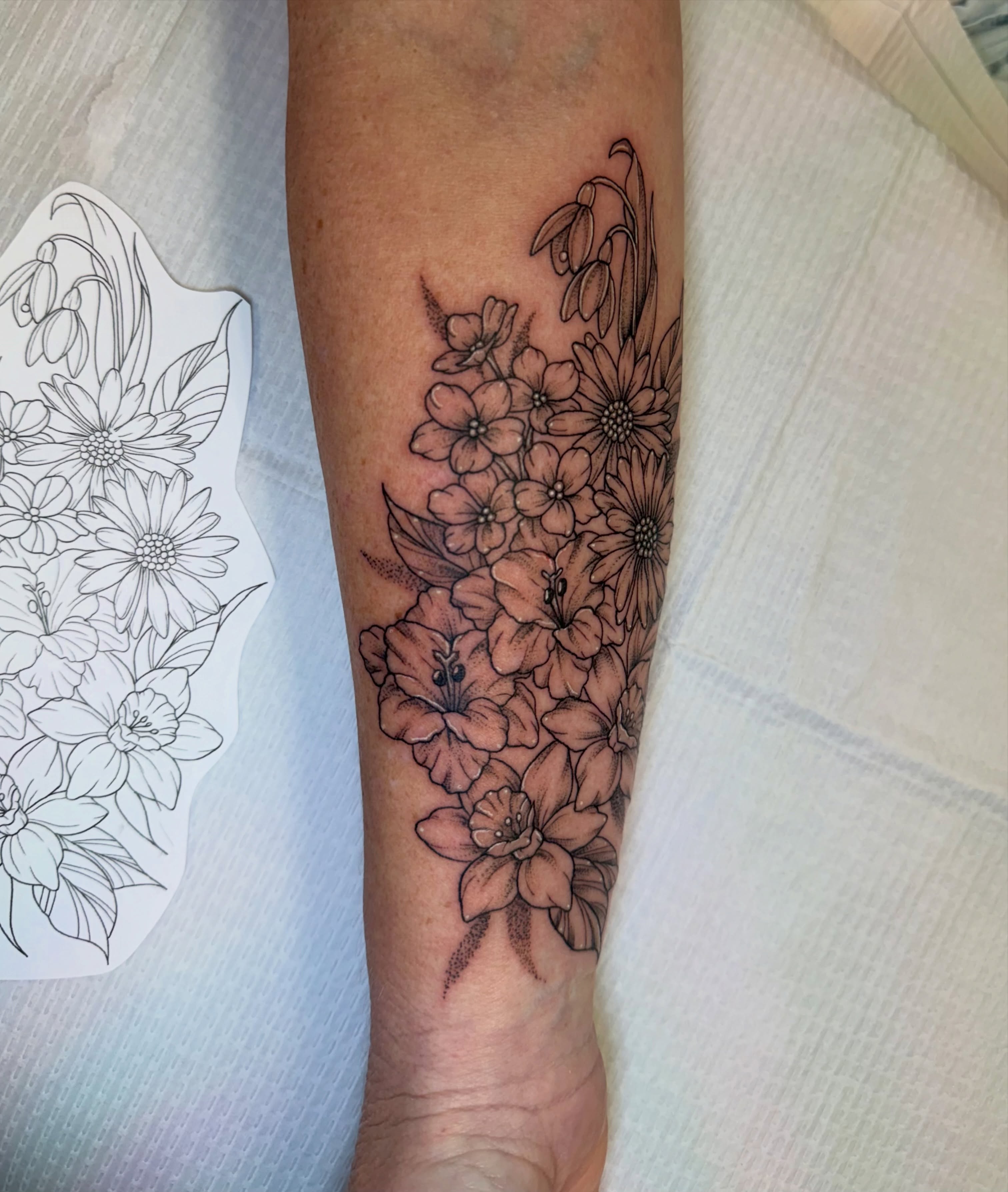 Floral bouquet black and grey tattoo on the forearm by McKenna