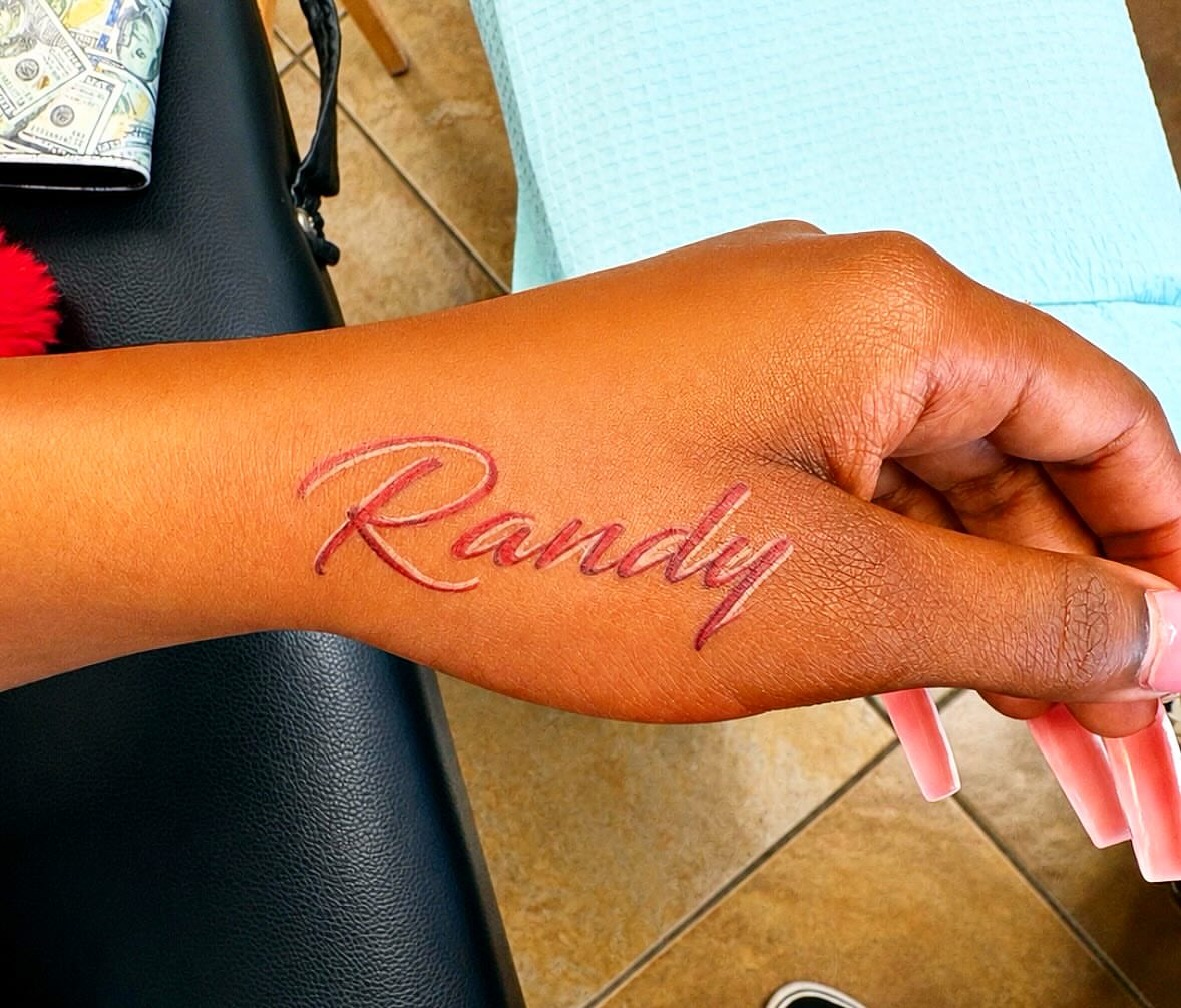 Name lettering script tattoo on the forearm by Stoney