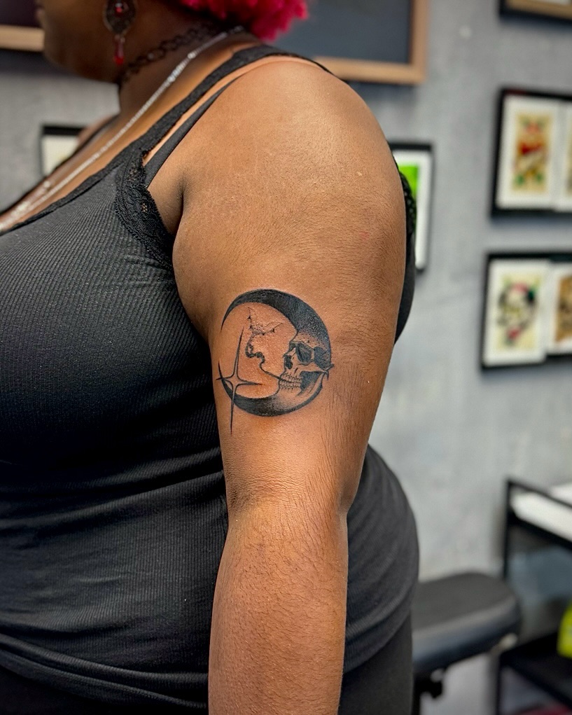 Skull and moon realism tattoo on the upper arm by David