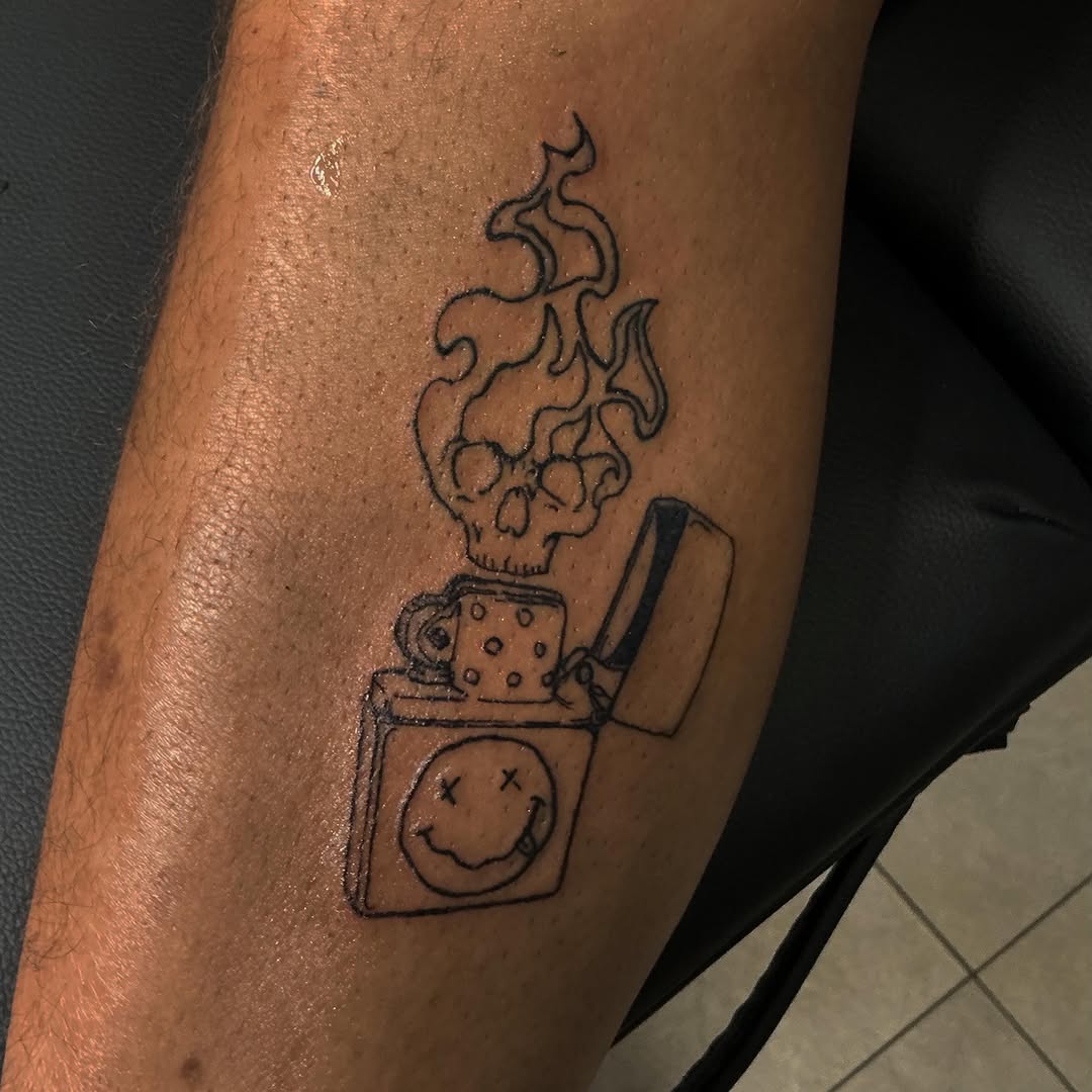 Skull lighter with smiley face minimalist tattoo on the forearm by Las Vegas Tattoo Artist ๐ฒโ๏ธ