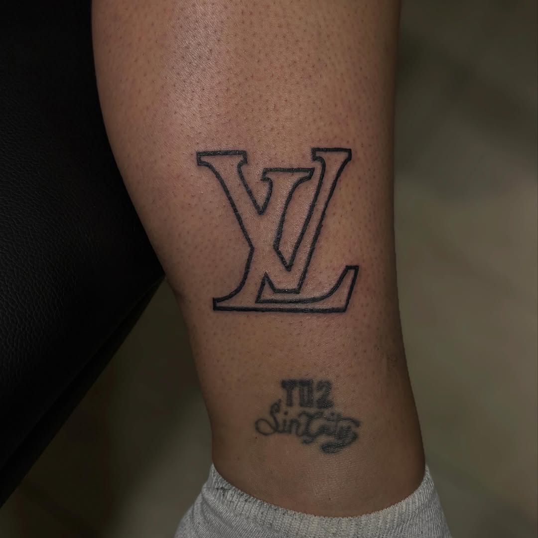 Louis Vuitton logo and script text blackwork tattoo on the forearm by Las Vegas Tattoo Artist ๐ฒโ๏ธ