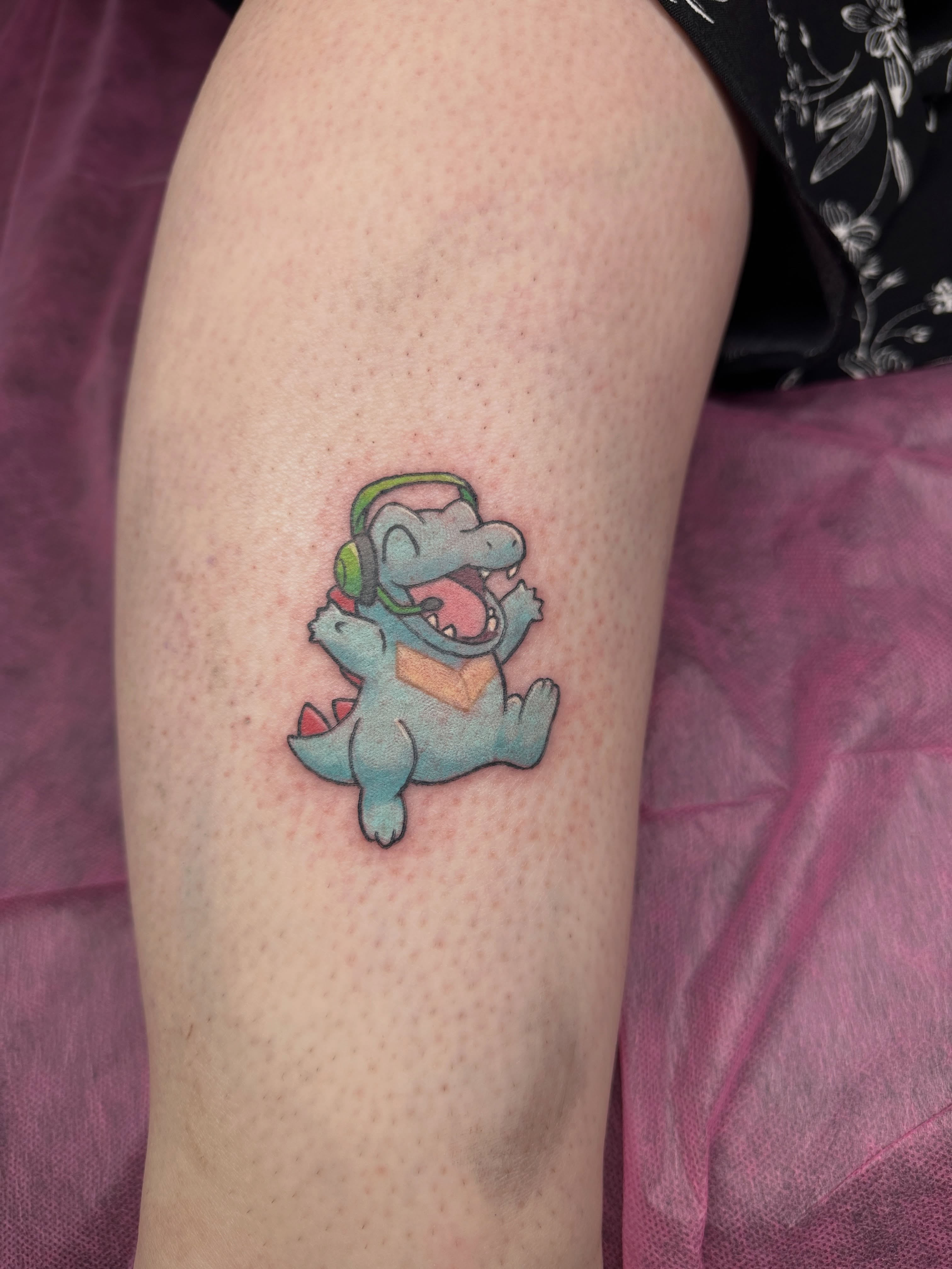 Dinosaur with headphones new school tattoo on the thigh by Shrimple