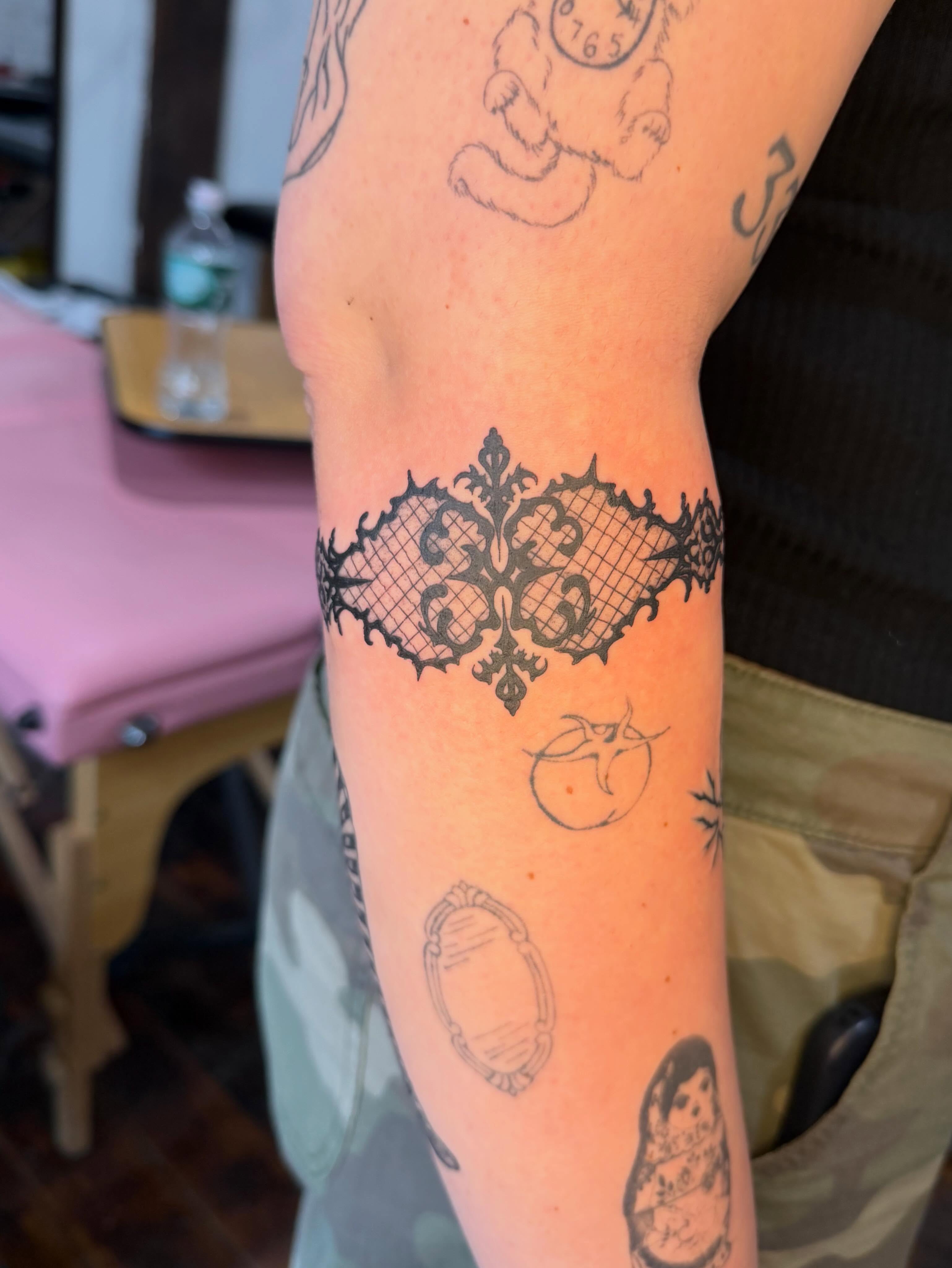 Lace pattern ornamental tattoo on the forearm by Mike Nappi