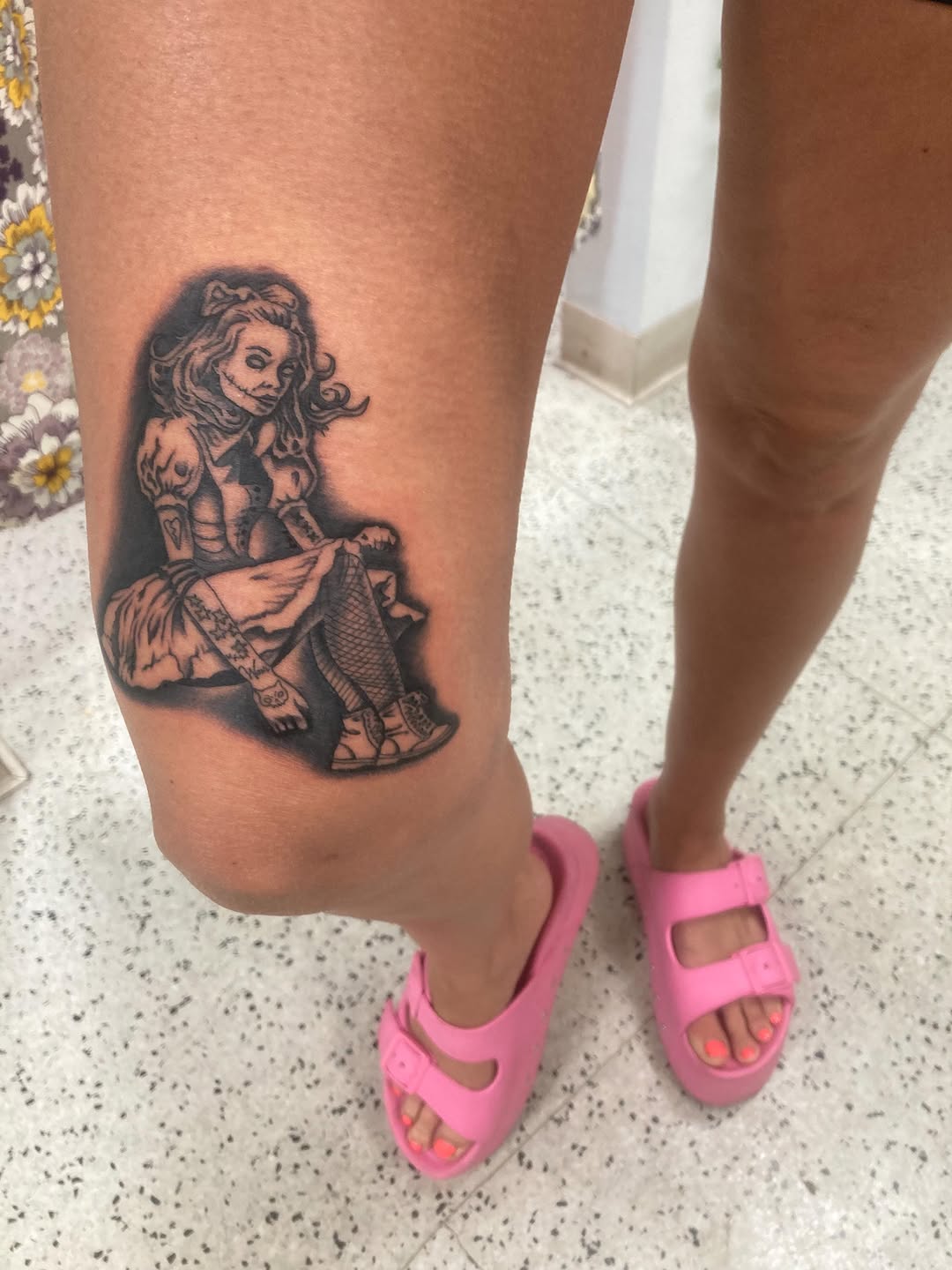 Creepy doll tattoo on the thigh by Timothy Murtaugh