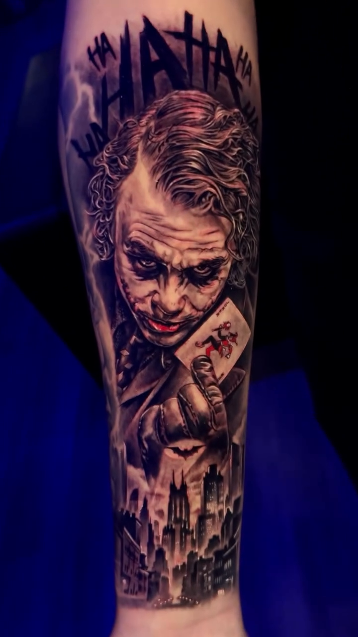 The Joker portrait with cityscape realism tattoo on the forearm by Raw Hound, Hialeah, Florida