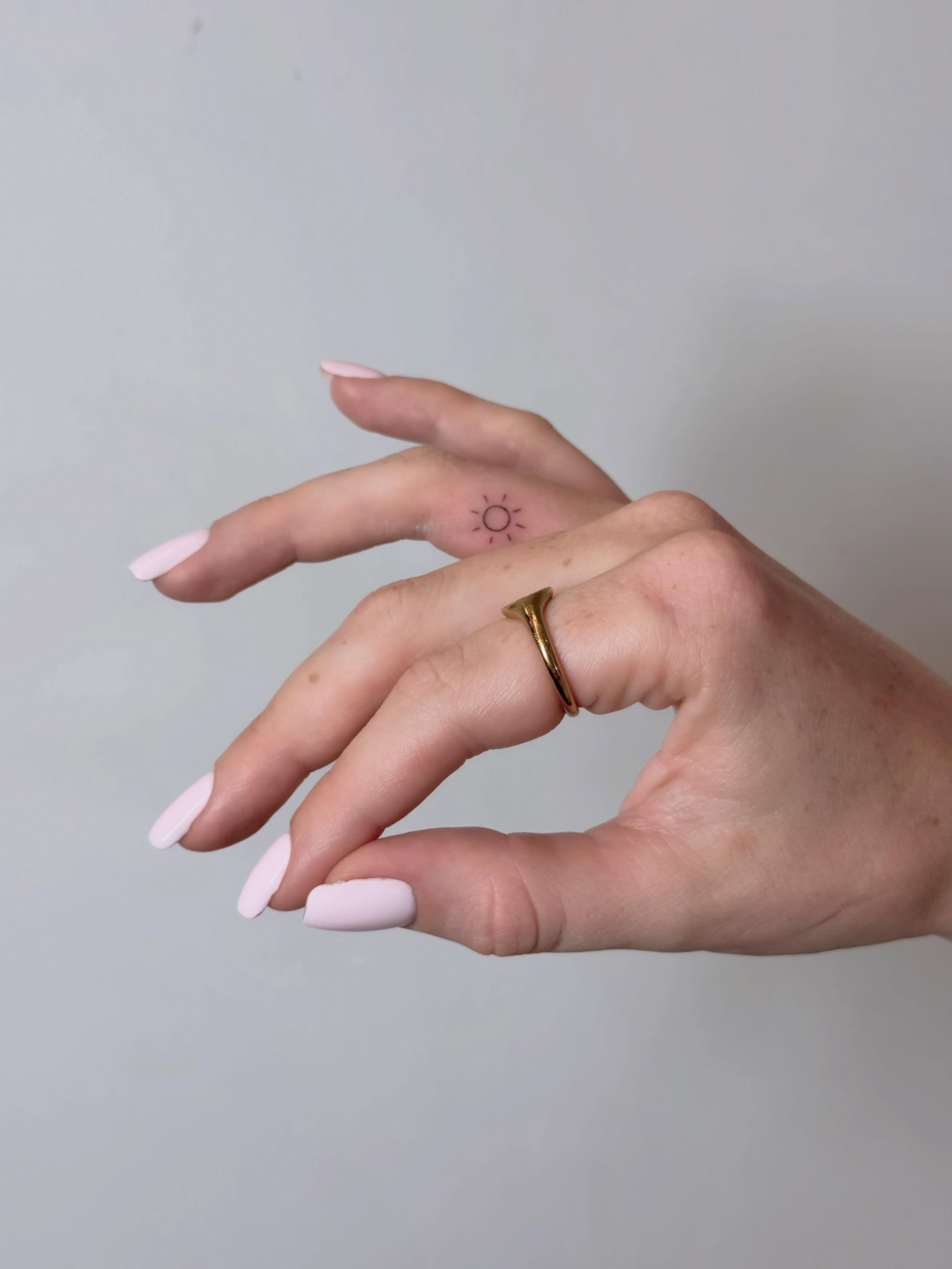 Sun fine line tattoo on the hand by Julia