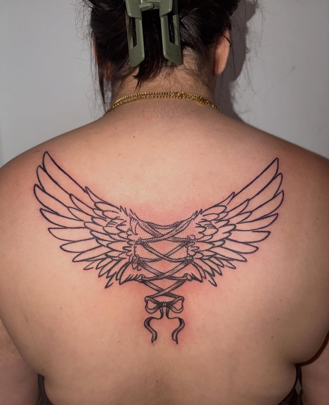 Wings and corset realism tattoo on the back by Comet