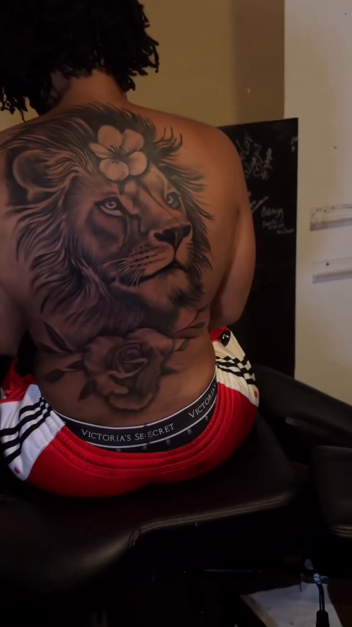 Lion with flowers on back Chicano tattoo on the back by Chicago Tattoo Artist